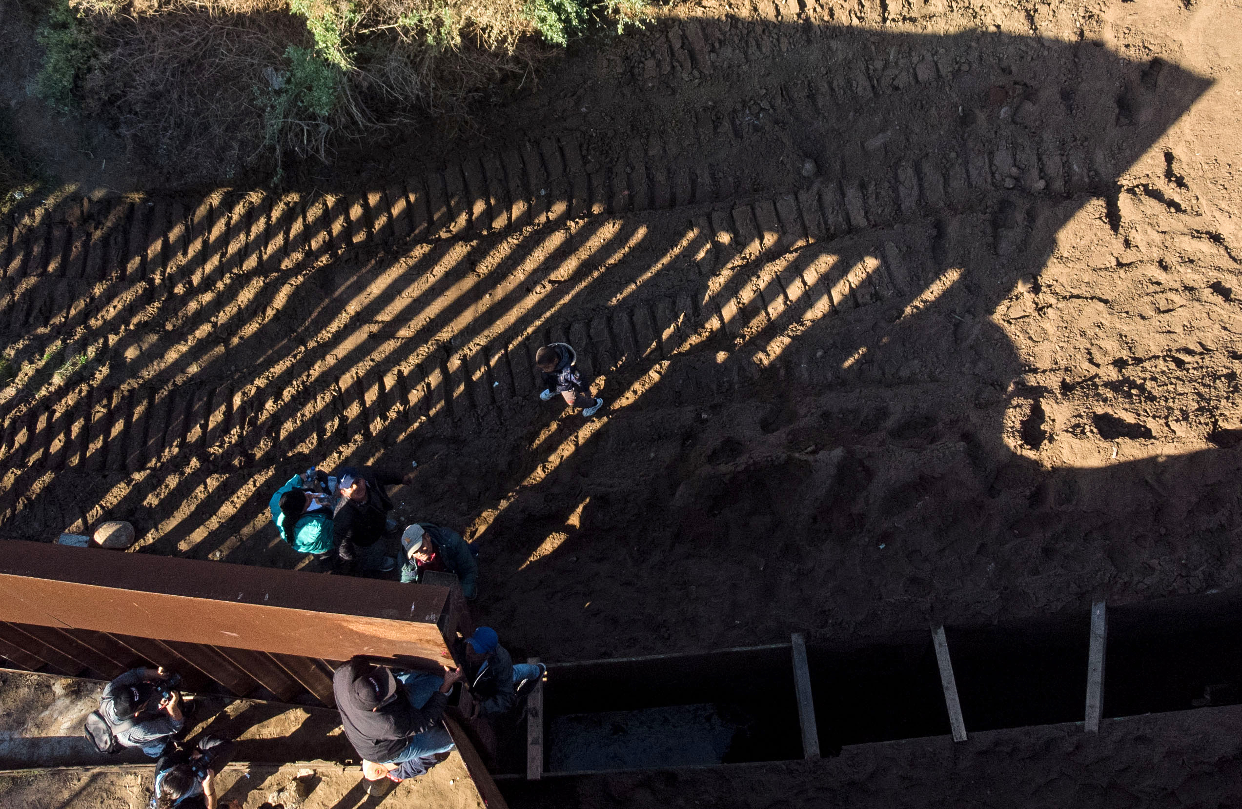 Aerial view of a group of Honduran migrants traveling in the Central American caravan, crossing the Mexico-US border fence to San Diego County, as seen from Playas de Tijuana, Baja California state, Mexico on December 12, 2018. - Thousands of Central American migrants have trekked for over a month in the hopes of reaching the United States. (Photo by GUILLERMO ARIAS/AFP/Getty Images)