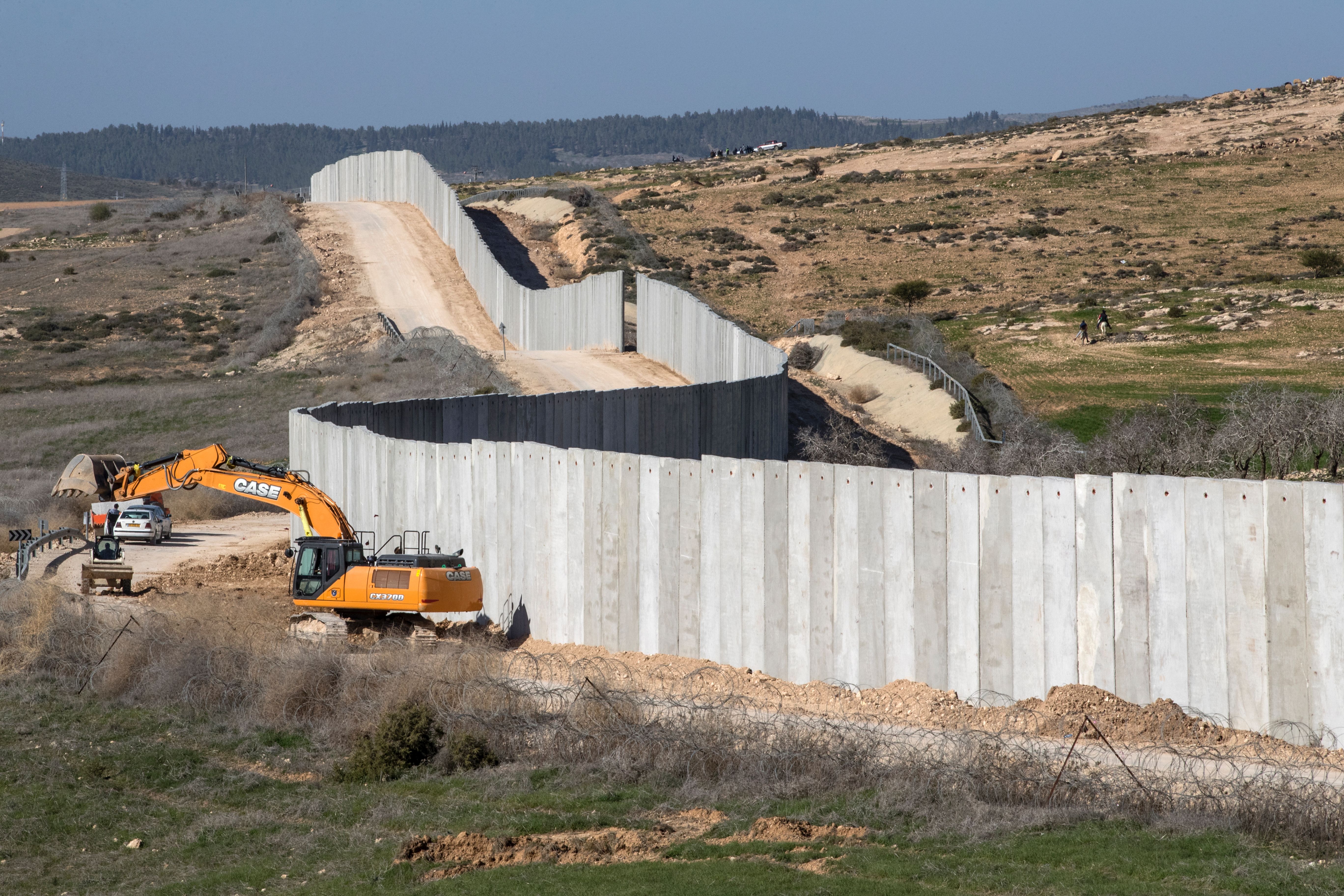 A picture taken near the southern kibbutz of Lahav on February 7, 2017, shows workers building a new section of the controversial Israeli separation wall dividing Israel from the West Bank. (JACK GUEZ/AFP/Getty Images)