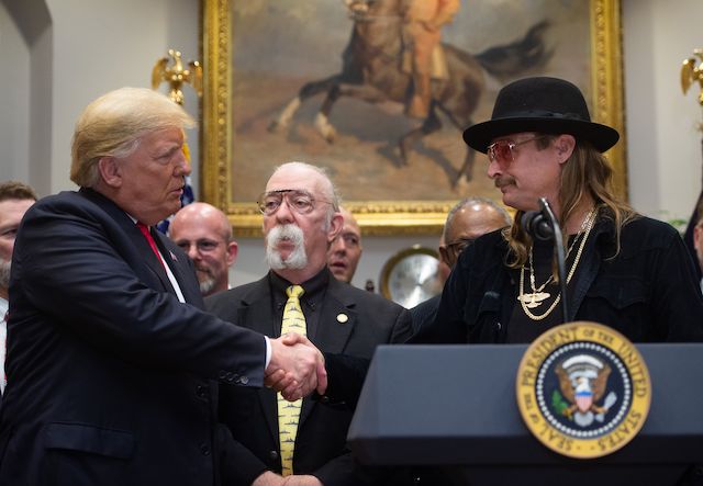 US President Donald Trump shakes hands with musician Kid Rock (R) after signing the Hatch-Goodlatte Music Modernization Act, a bipartisan bill aimed at ensuring artists who released records prior to 1972 are paid royalties from digital services, in the Roosevelt Room of the White House in Washington, DC, October 11, 2018. (Photo credit: LOEB/AFP/Getty Images)