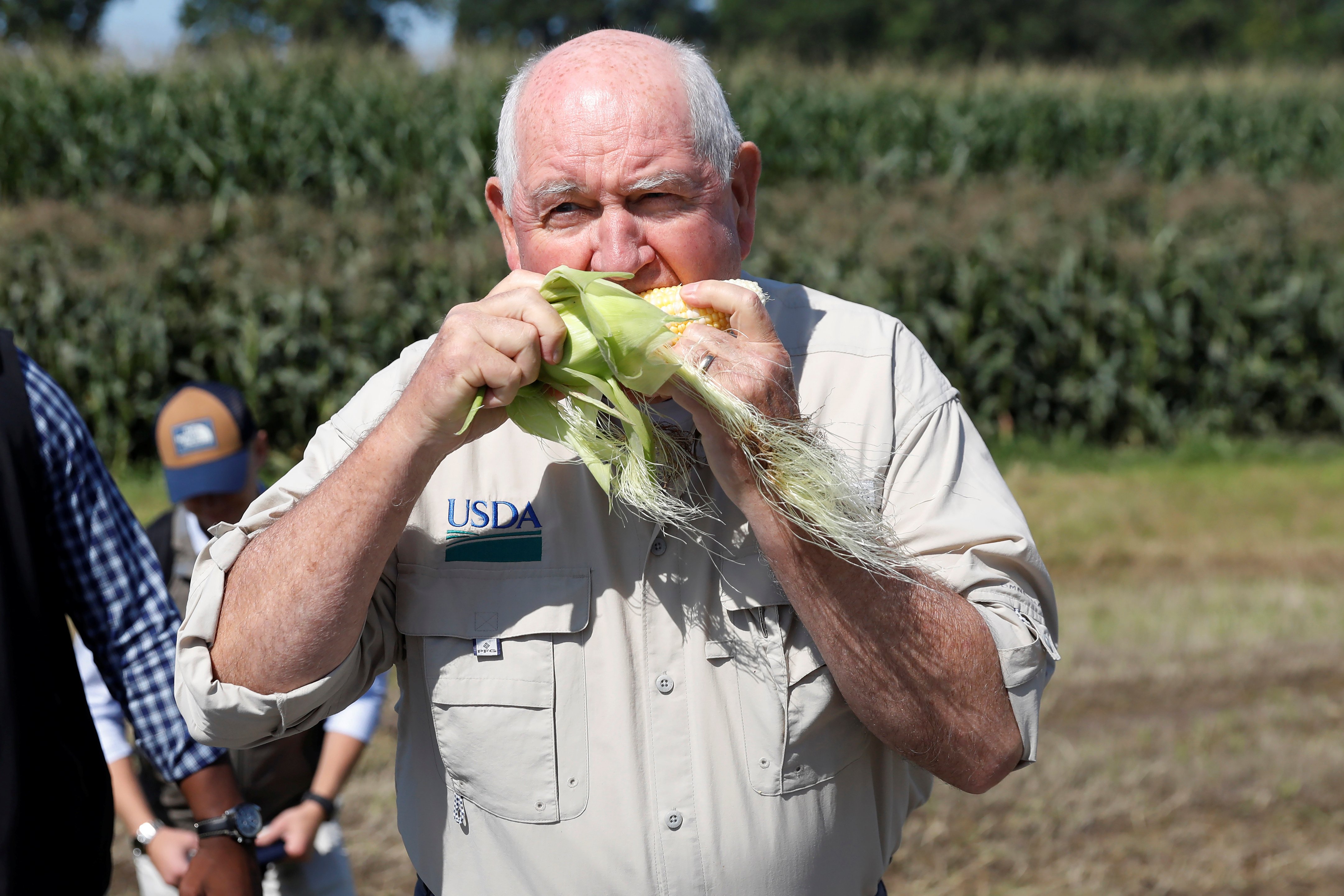 U.S. Agriculture Secretary Sonny Perdue eats an ear of corn at the Brabant Farms in Verona
