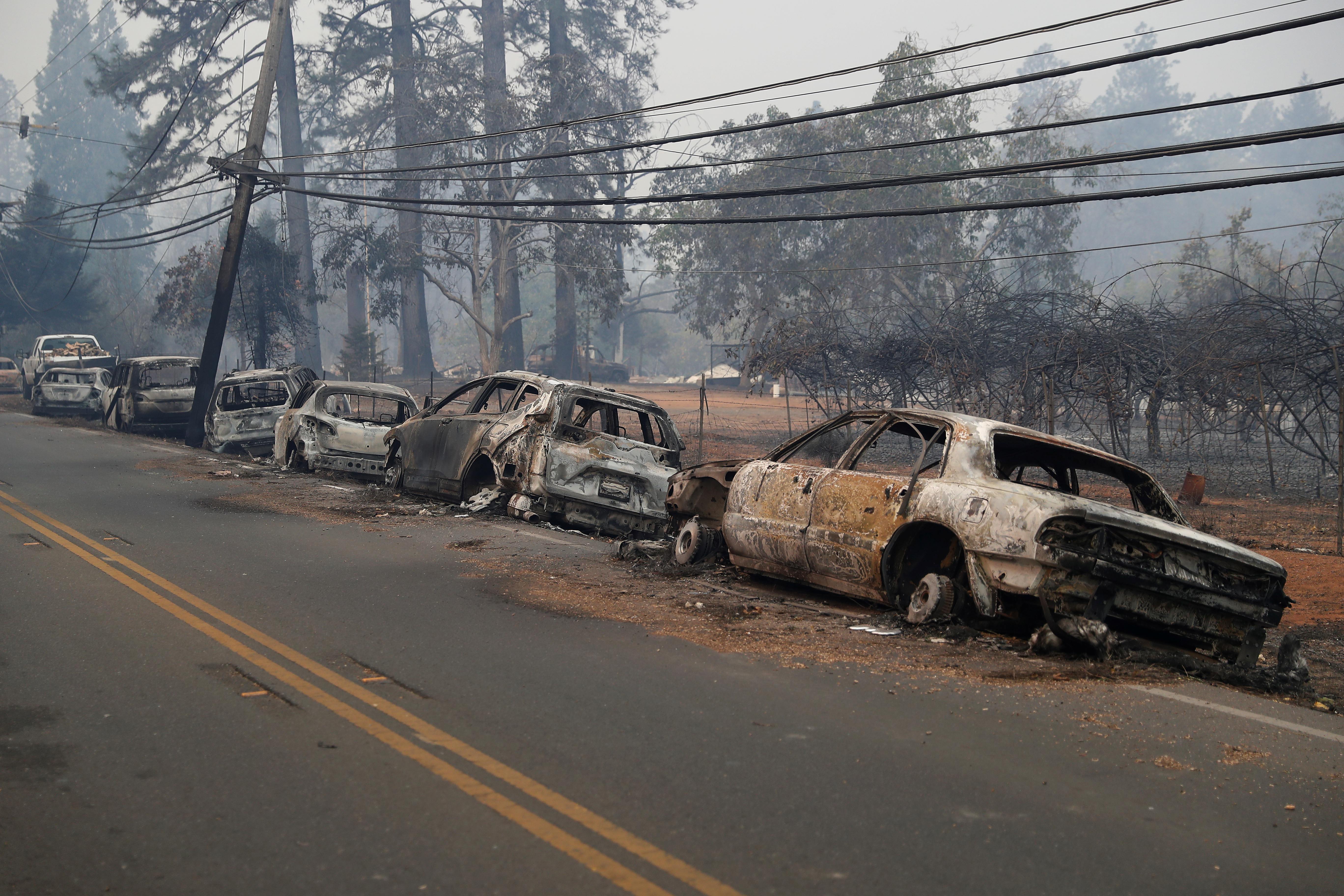 A row of burned vehicles are seen on Skyway during the Camp Fire in Paradise