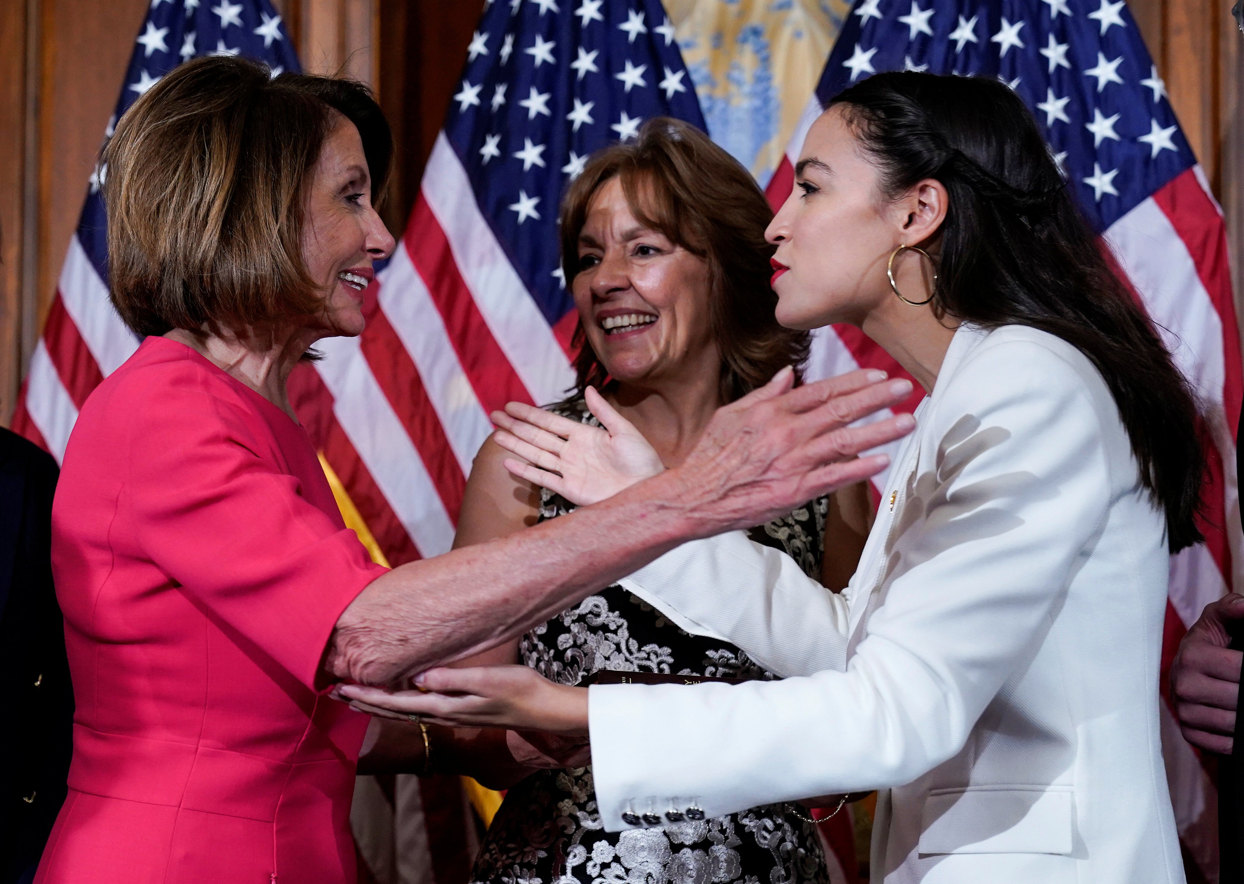 Rep. Alexandria Ocasio-Cortez (D-NY) greets Speaker of the House Nancy Pelosi (D-CA) before a ceremonial swearing-in picture on Capitol Hill in Washington