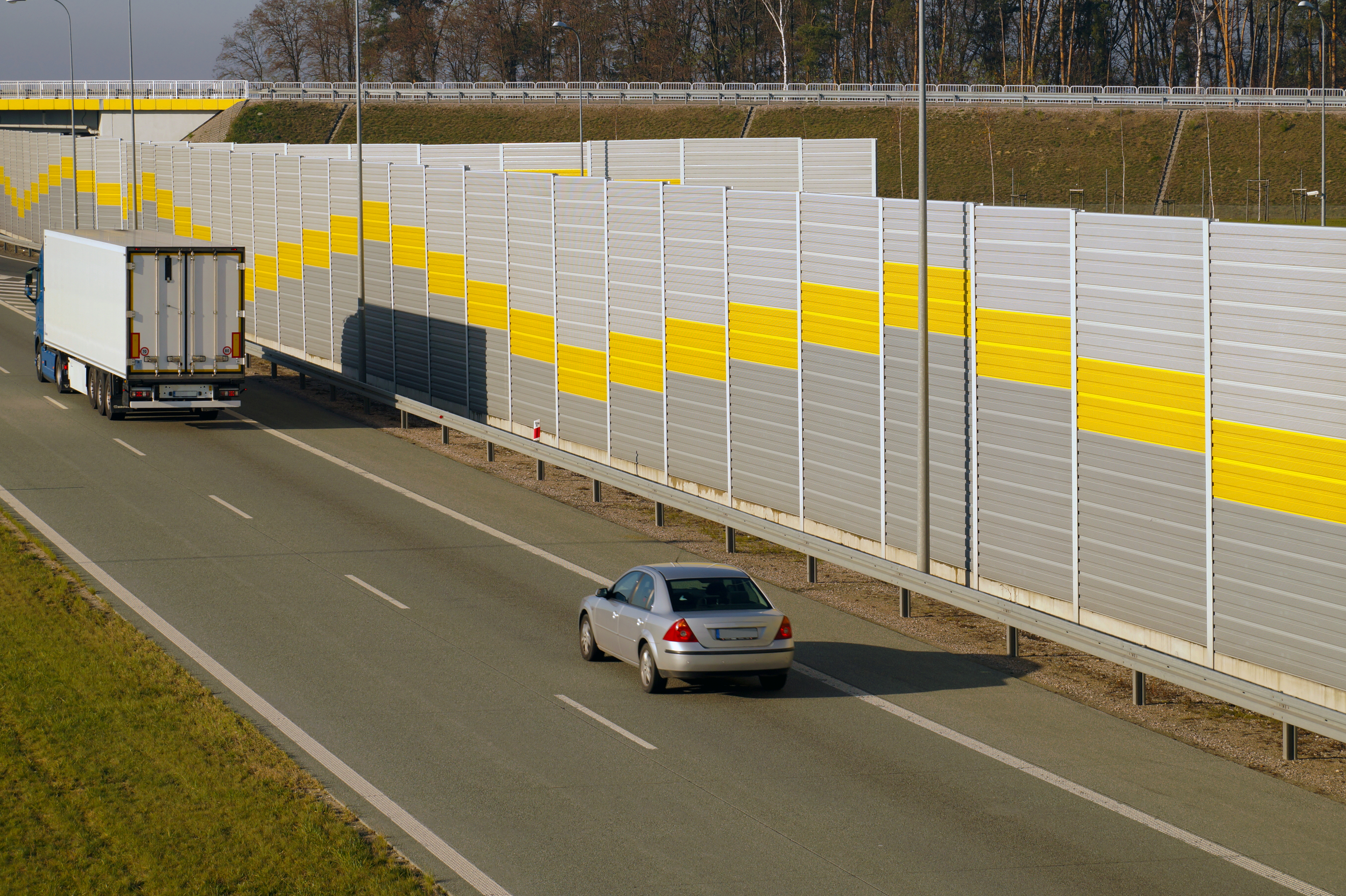 Highway edged by a sound barrier wall. (Shutterstock/vladdon)