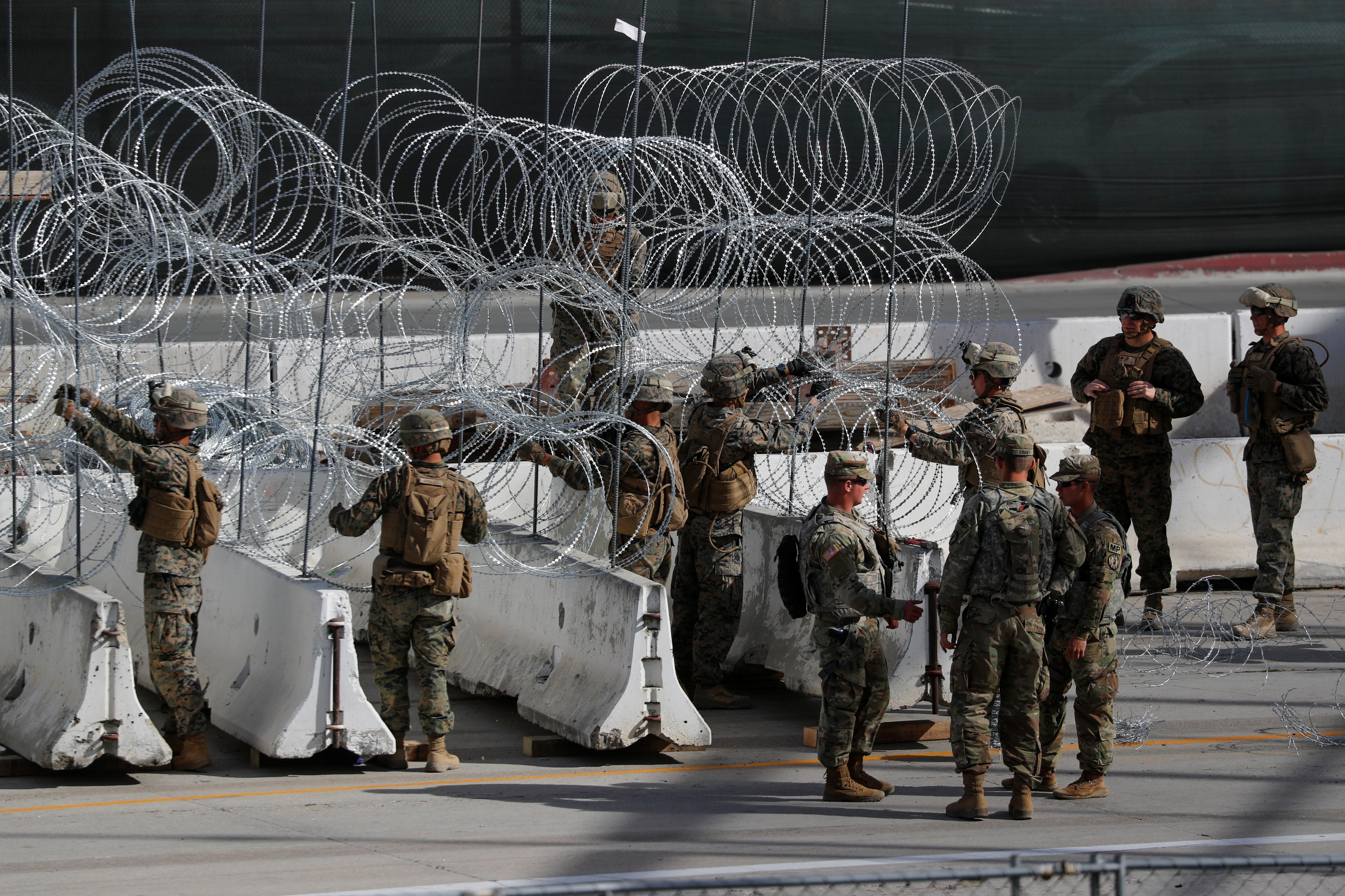 U.S. Marines help to build a concertina wire barricade at the U.S. Mexico border in preparation for the arrival of a caravan of migrants at the San Ysidro border crossing in San Diego