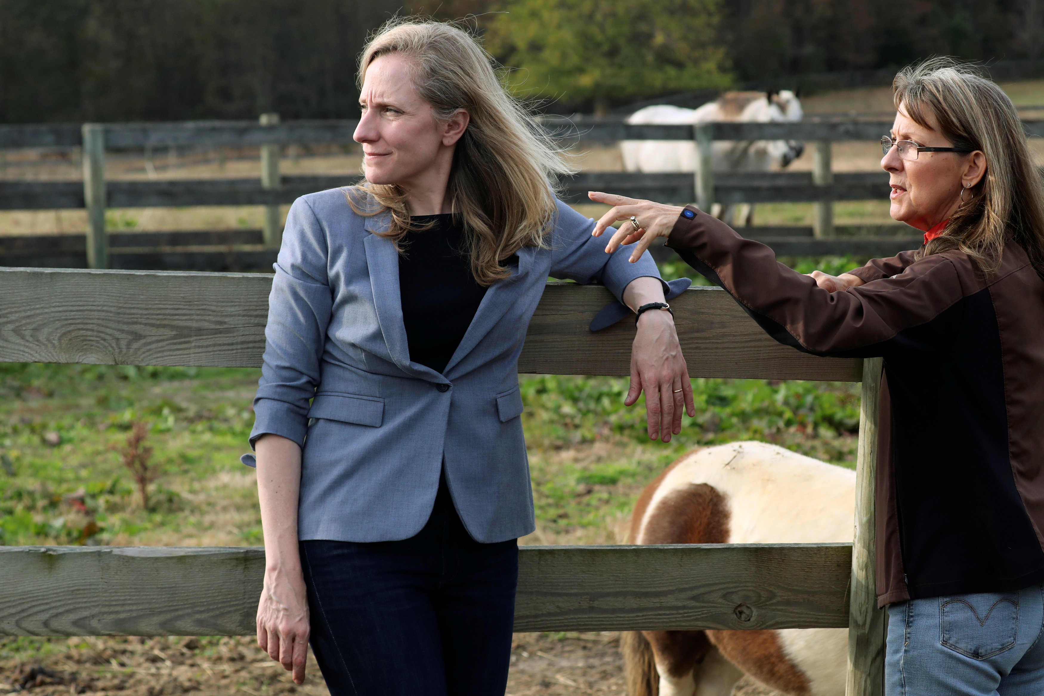 Virginia Democratic candidate for U.S. Representative Abigail Spanberger (L) talks with Jorg Huckabee-Mayfield during a visit to the horse rescue stables she and her husband operate in Burkeville, Virginia, U.S. October 31, 2018. REUTERS/Jonathan Ernst