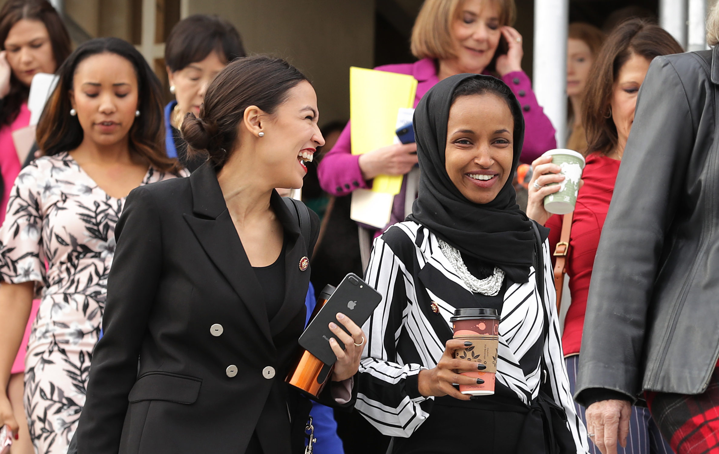 Rep. Alexandria Ocasio-Cortez (D-NY) (L) and Rep. Ilhan Omar (D-MN) (C) join their fellow House Democratic women for a portrait in front of the U.S. Capitol January 04, 2019 in Washington, DC. Chip Somodevilla/Getty Images
