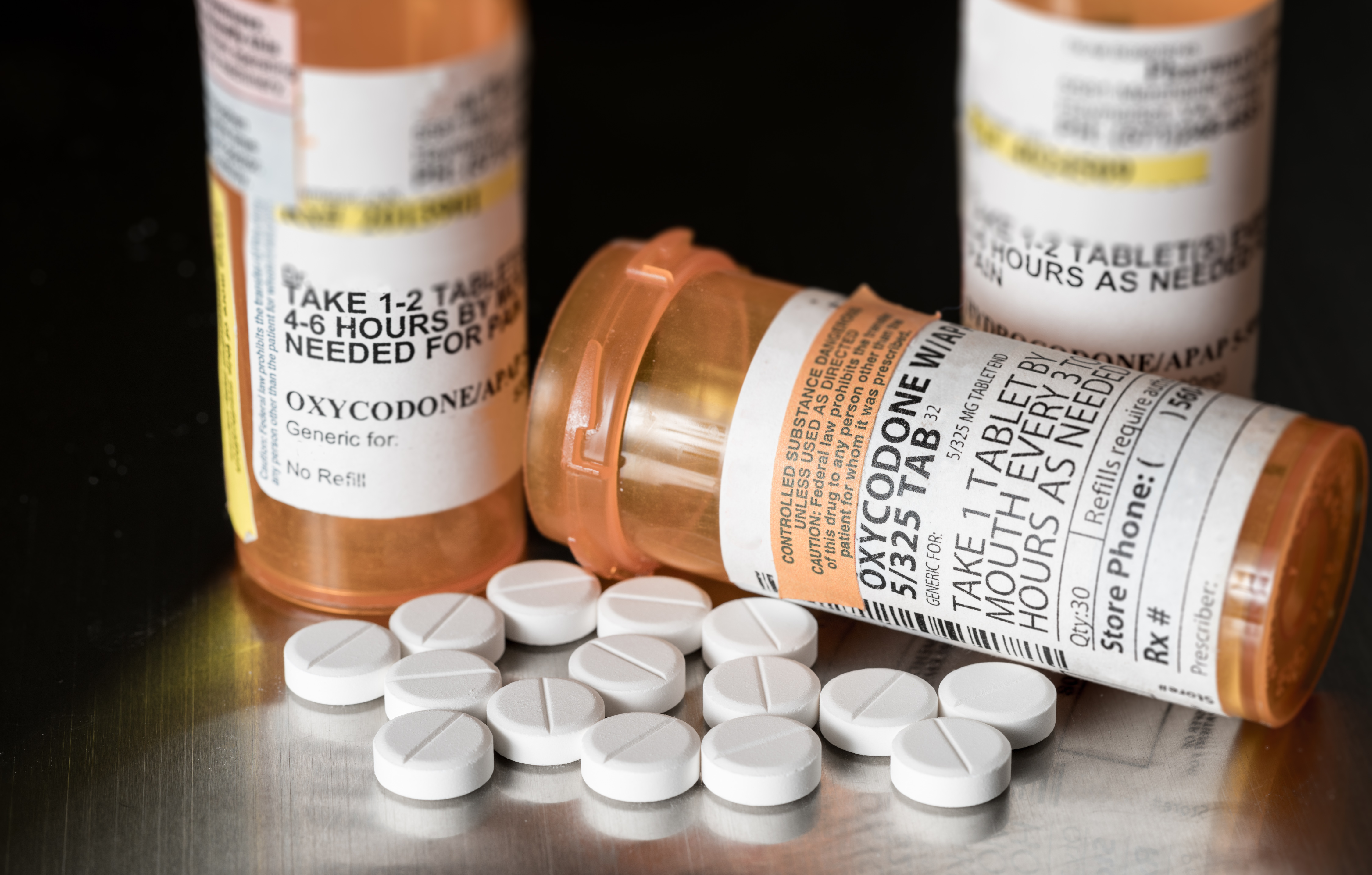 Oxycodone is the generic name for a range of opoid pain killing tablets. Prescription bottle for Oxycodone tablets and pills on metal table for opioid epidemic illustration. (Shutterstock/Steve Heap)