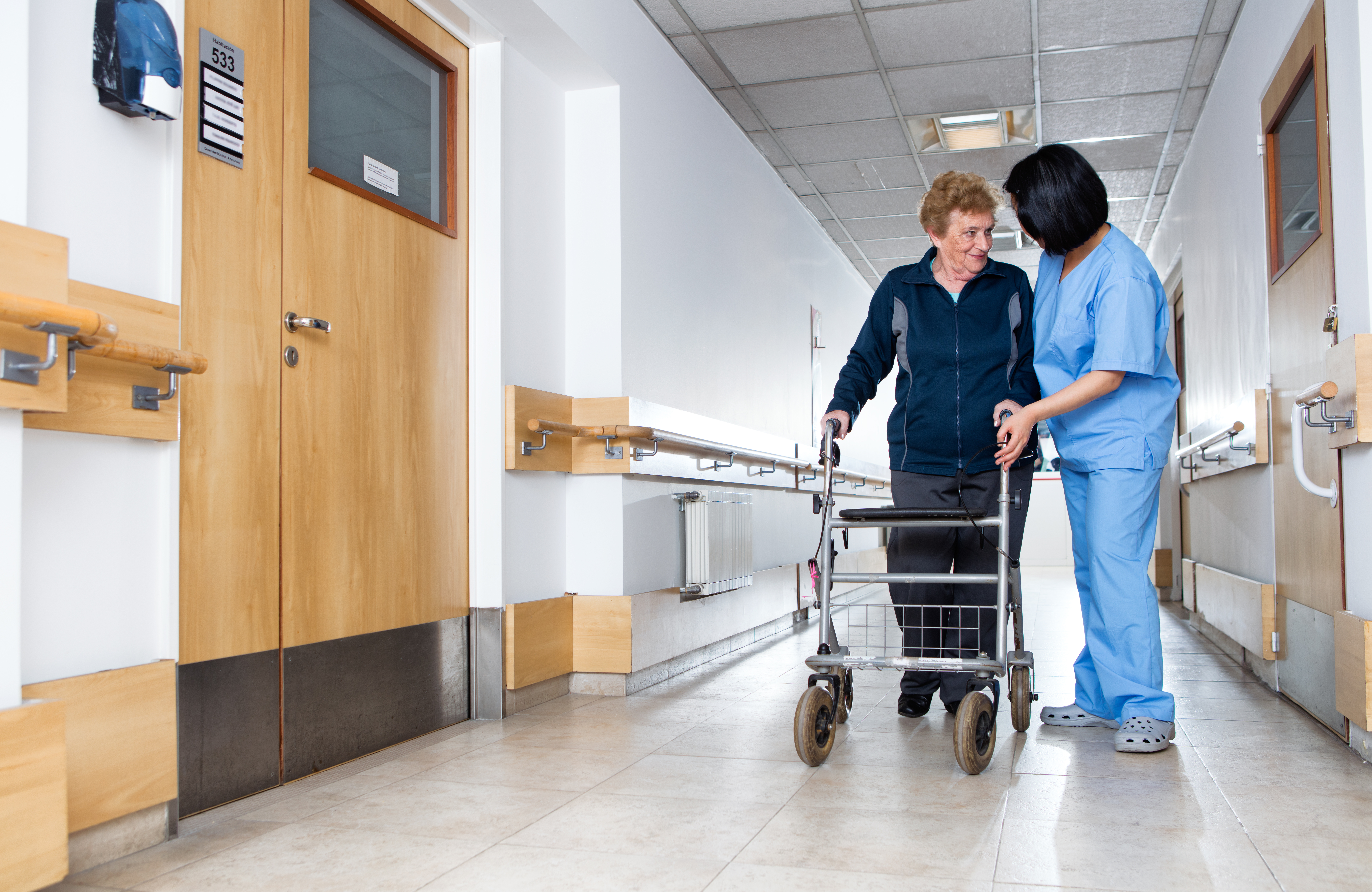 A caretaker and patient at a nursing facility. Shutterstock image via user GagliardiImages