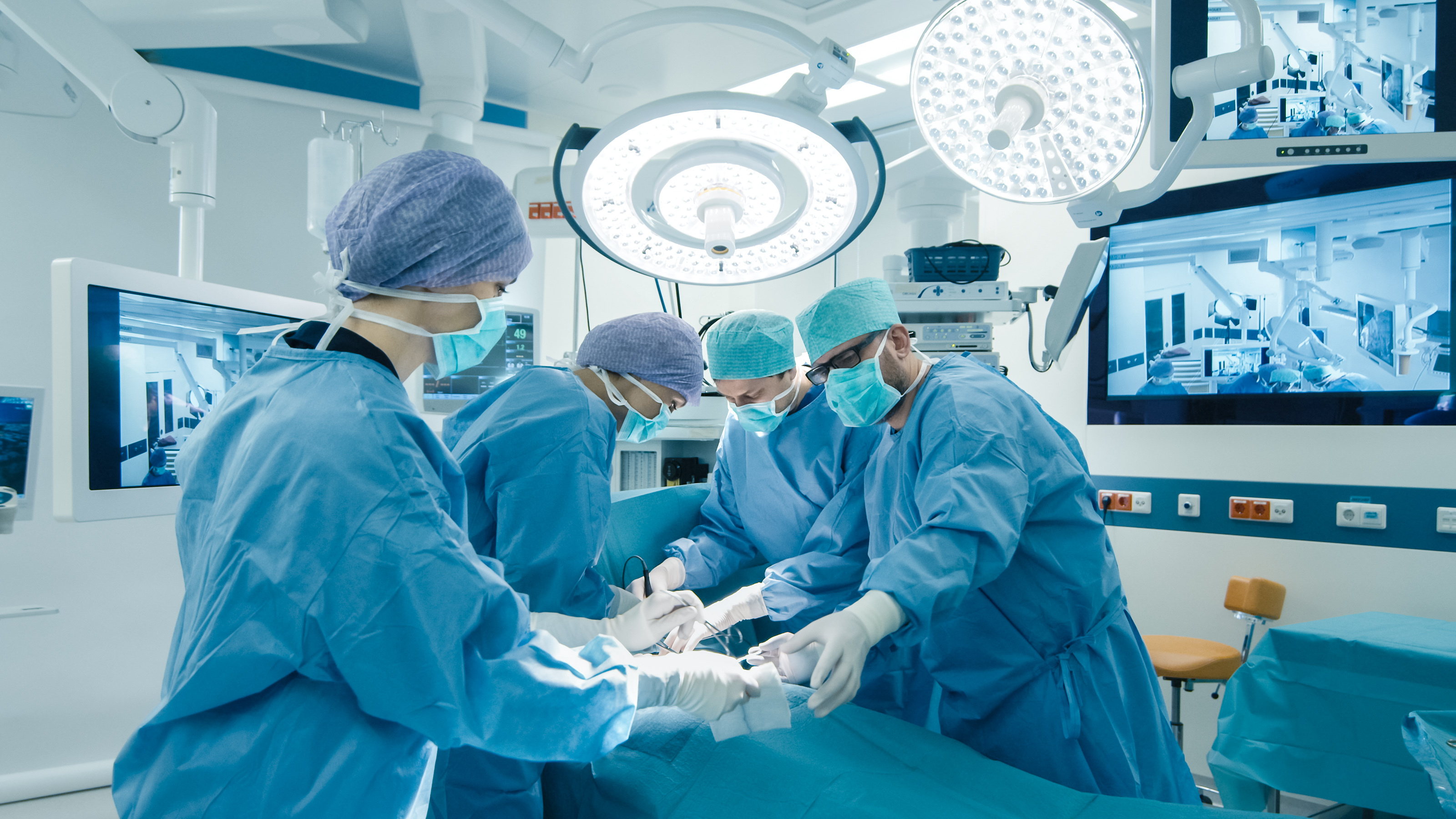 Doctors perform surgery. Shutterstock image via user Gorodenkoff