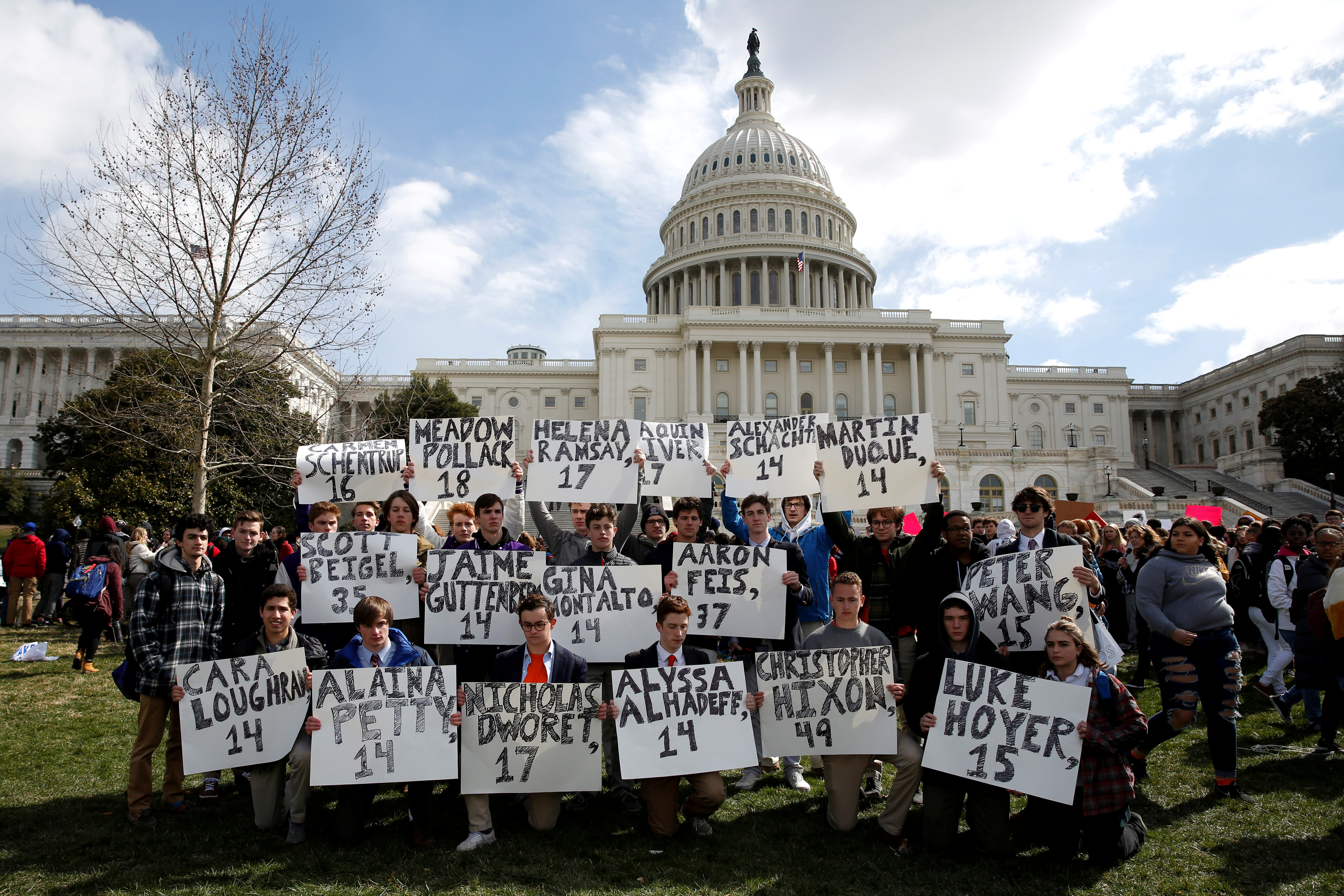 Students from Gonzaga College High School in Washington, DC, hold up signs with the names of those killed in the Parkland, Florida, school shooting during a protest for stricter gun control during a walkout by students at the U.S. Capitol in Washington, U.S., March 14, 2018. REUTERS/Joshua Roberts