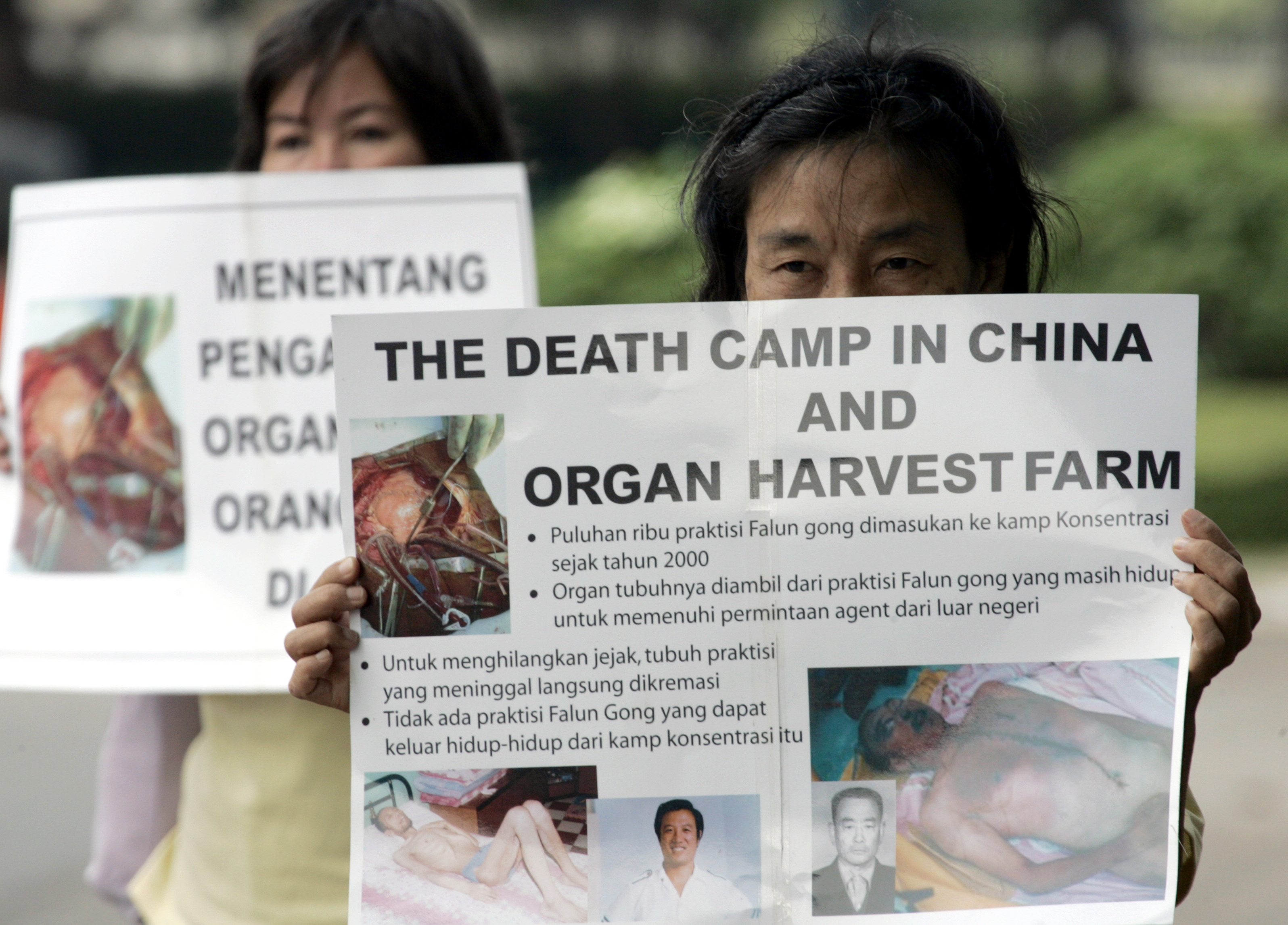 Indonesian Falun Gong followers carry placards during a protest in front of U.S. embassy in Jakarta April 19, 2006. REUTERS/Beawiharta