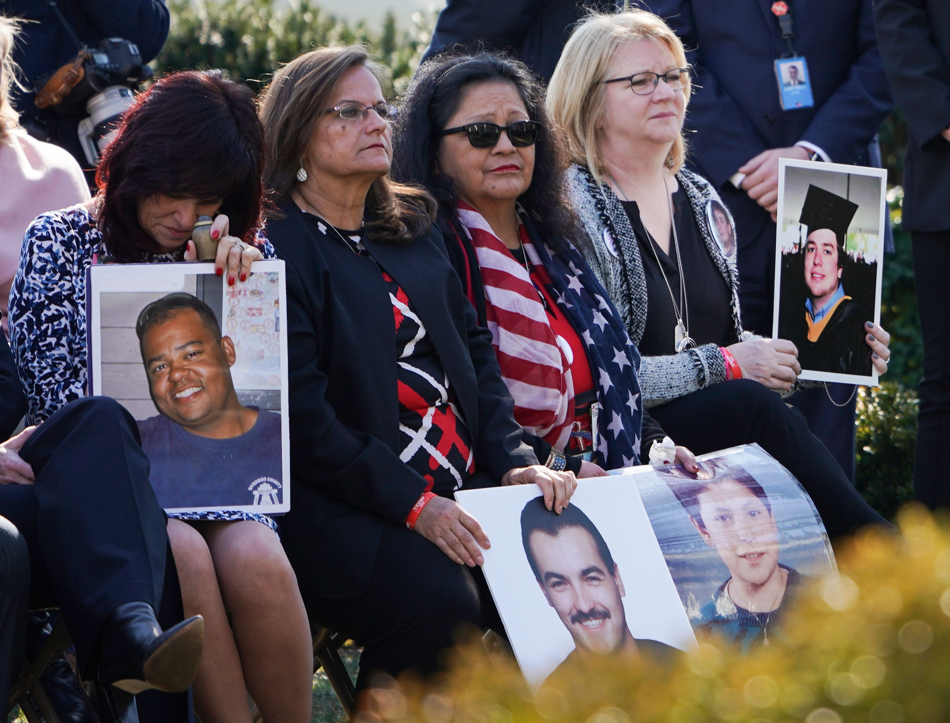 Family members hold portraits of loved one that were victims of crimes committed by undocumented immigrants, as US President Donald Trump delivers remarks, in the Rose Garden at the White House in Washington, DC on February 15, 2019. (Photo by BRENDAN SMIALOWSKI/AFP/Getty Images)
