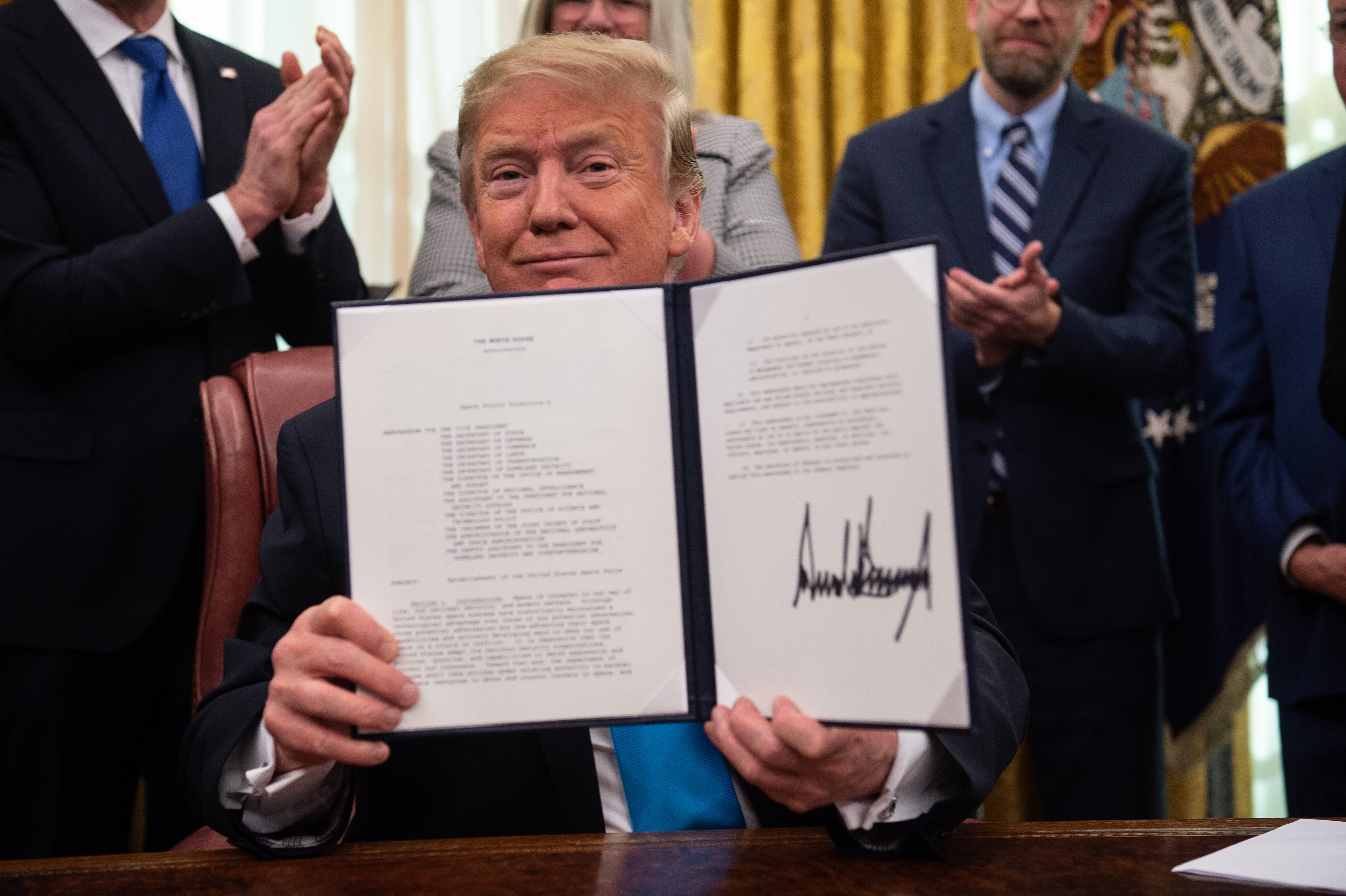 US President Donald Trump shows his signature on the Space Policy Directive-4 (SPD-4) on February 19, 2019, at the White House in Washington, DC. (NICHOLAS KAMM/AFP/Getty Images)
