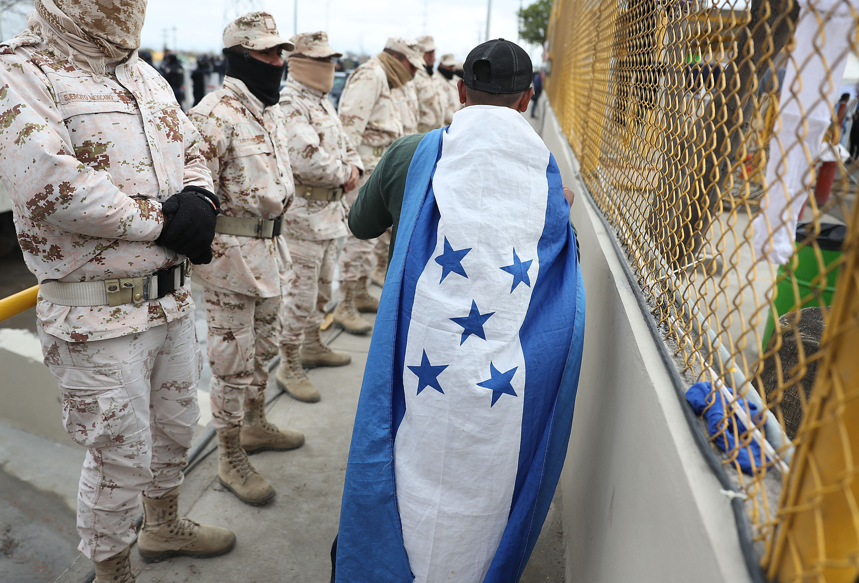 Jose Martinez, from Honduras, wears his countries flag as he joins other migrants, most of whom are part of a recently arrived caravan, at a migrant hostel as they wait to apply for asylum in to the United States on February 09, 2019 in Piedras Negras, Mexico. (Photo by Joe Raedle/Getty Images)