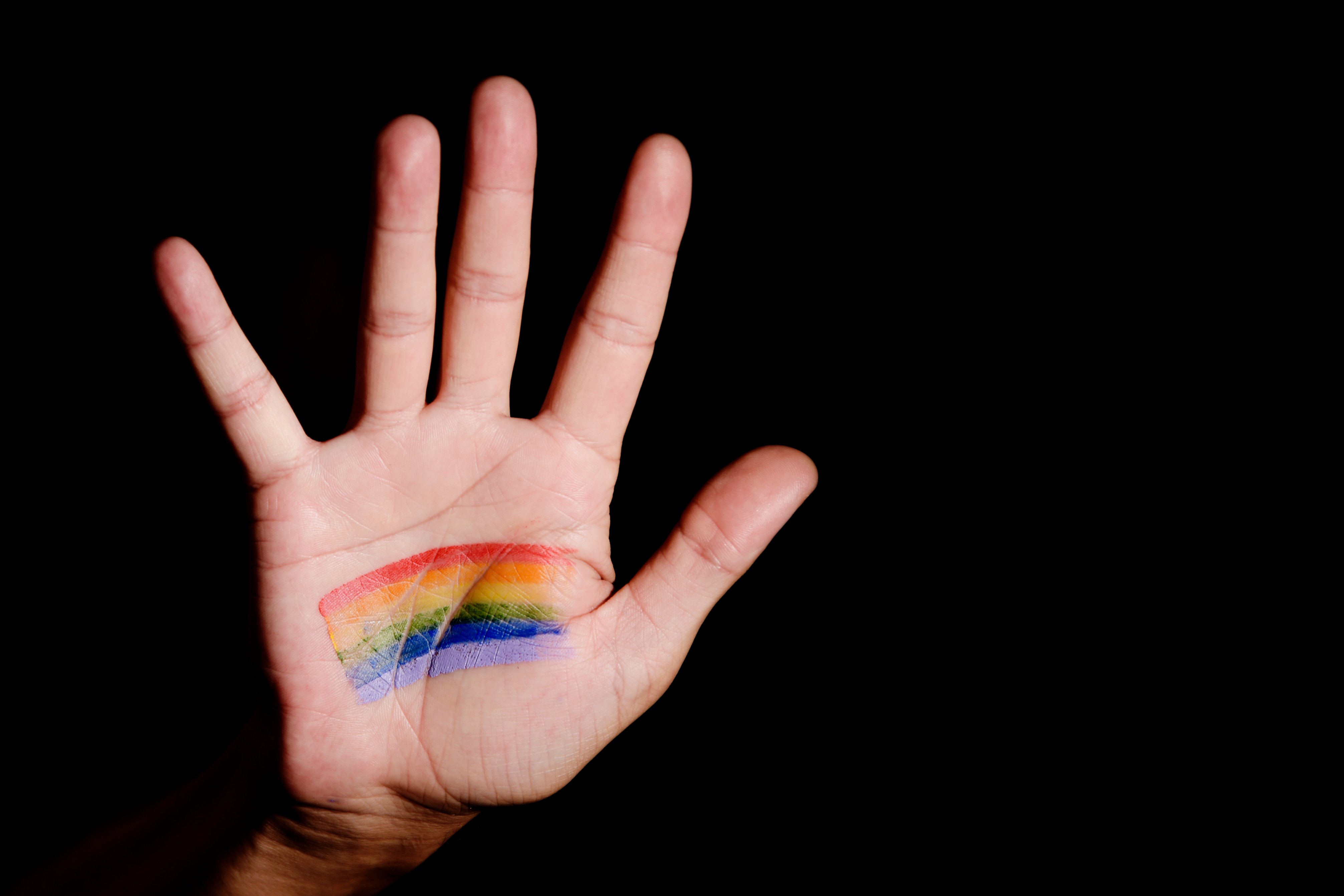 Pictured is a hand with a rainbow. SHUTTERSTOCK/ nito