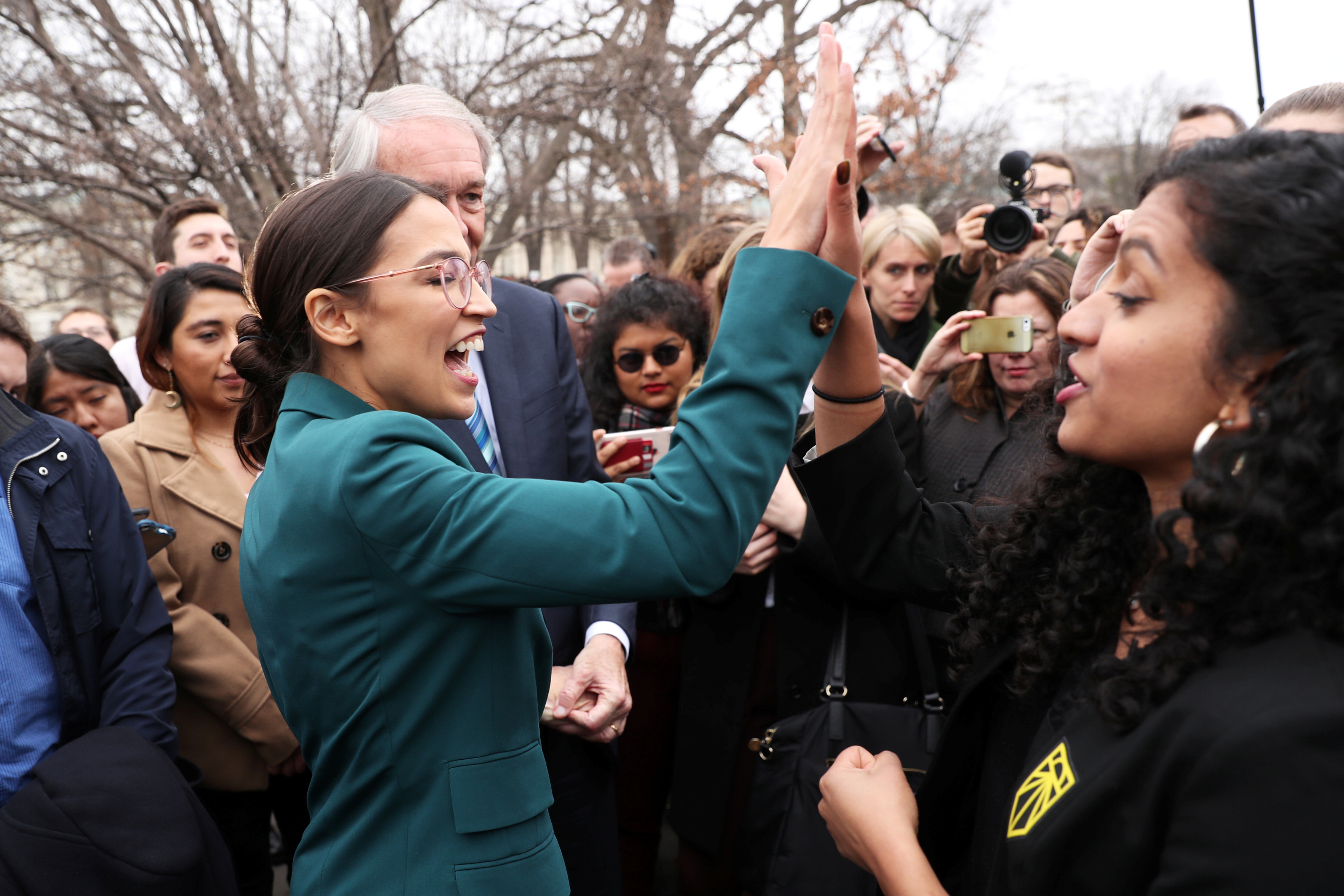 U.S. Representative Ocasio-Cortez and Senator Markey celebrate with activists after a news conference for their proposed "Green New Deal" at the U.S. Capitol in Washington