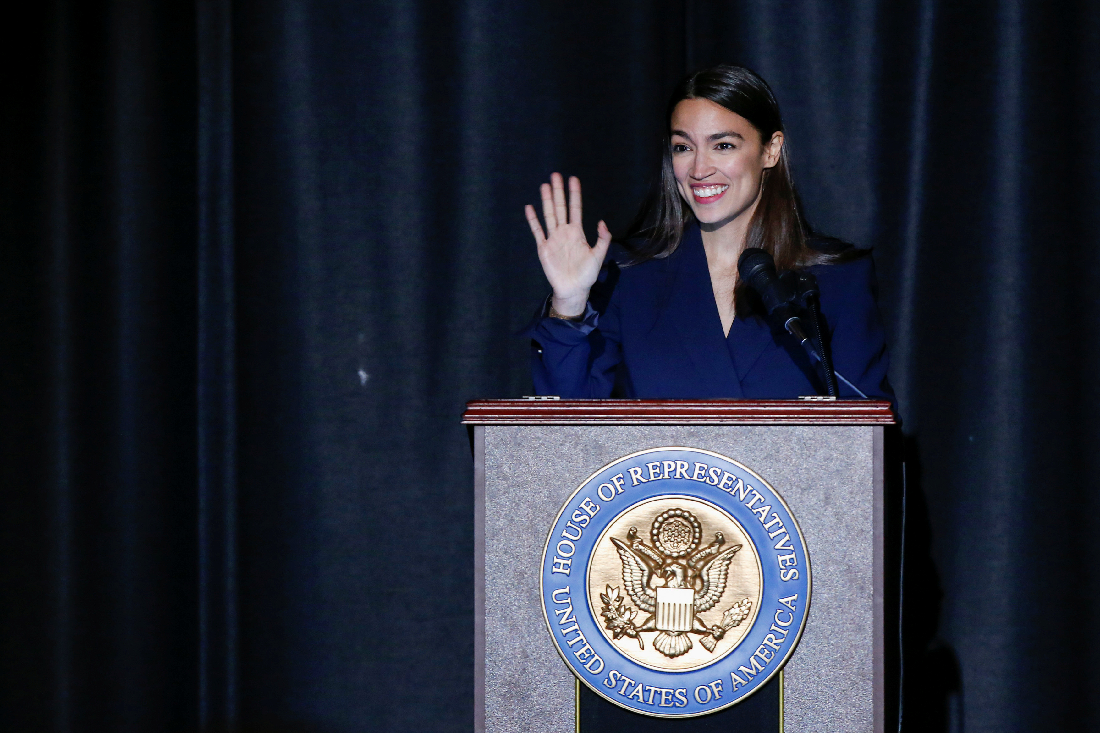 U.S. Rep. Ocasio-Cortez waves to attendees during her official swearing-in ceremony in the borough of Bronx, New York