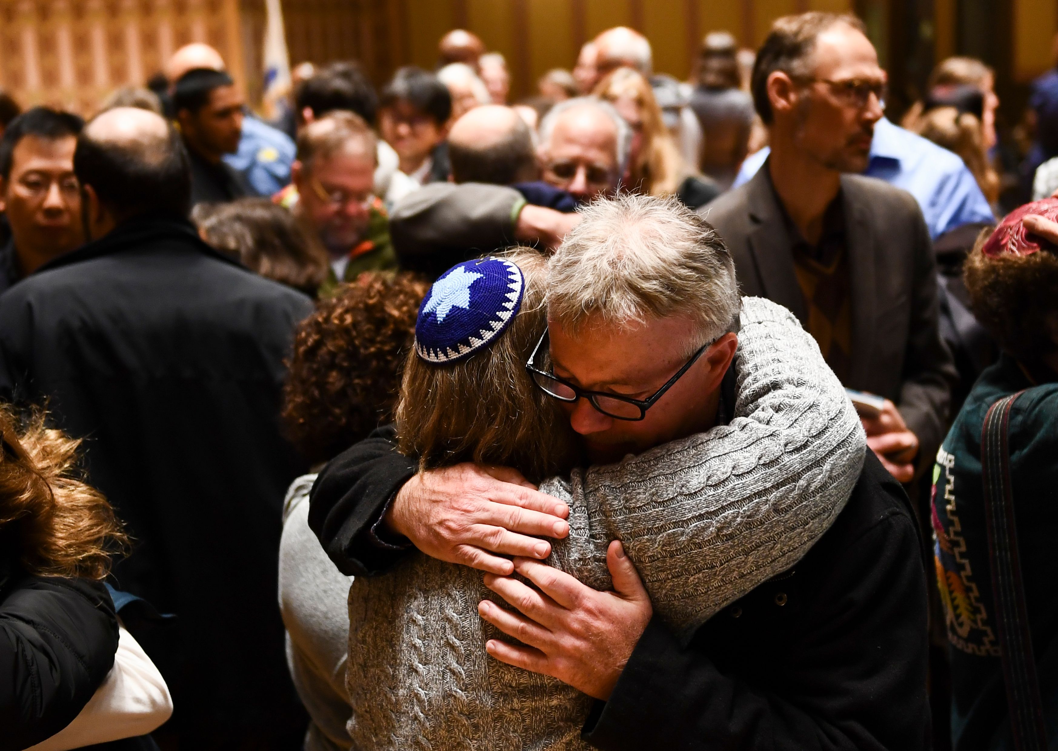 People hug after a vigil, to remember the victims of the shooting at the Tree of Life synagogue the day before, at the Allegheny County Soldiers Memorial on October 28, 2018, in Pittsburgh, Pennsylvania. (BRENDAN SMIALOWSKI/AFP/Getty Images)