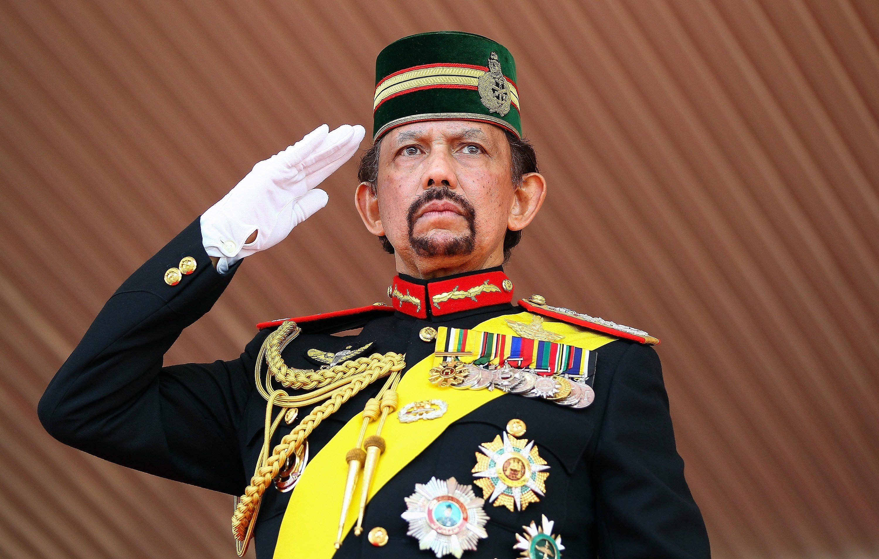 Brunei's Sultan Hassanal Bolkiah salutes during a ceremonial guard of honour to mark his 68th birthday celebrations in Bandar Seri Begawan on August 14, 2014. The monarch turned 68 on July 15, but the celebrations were postponed due to the holy month of Ramadan. The sultan is one of the world's longest-reigning monarchs. AFP PHOTO (Photo credit should read STR/AFP/Getty Images)