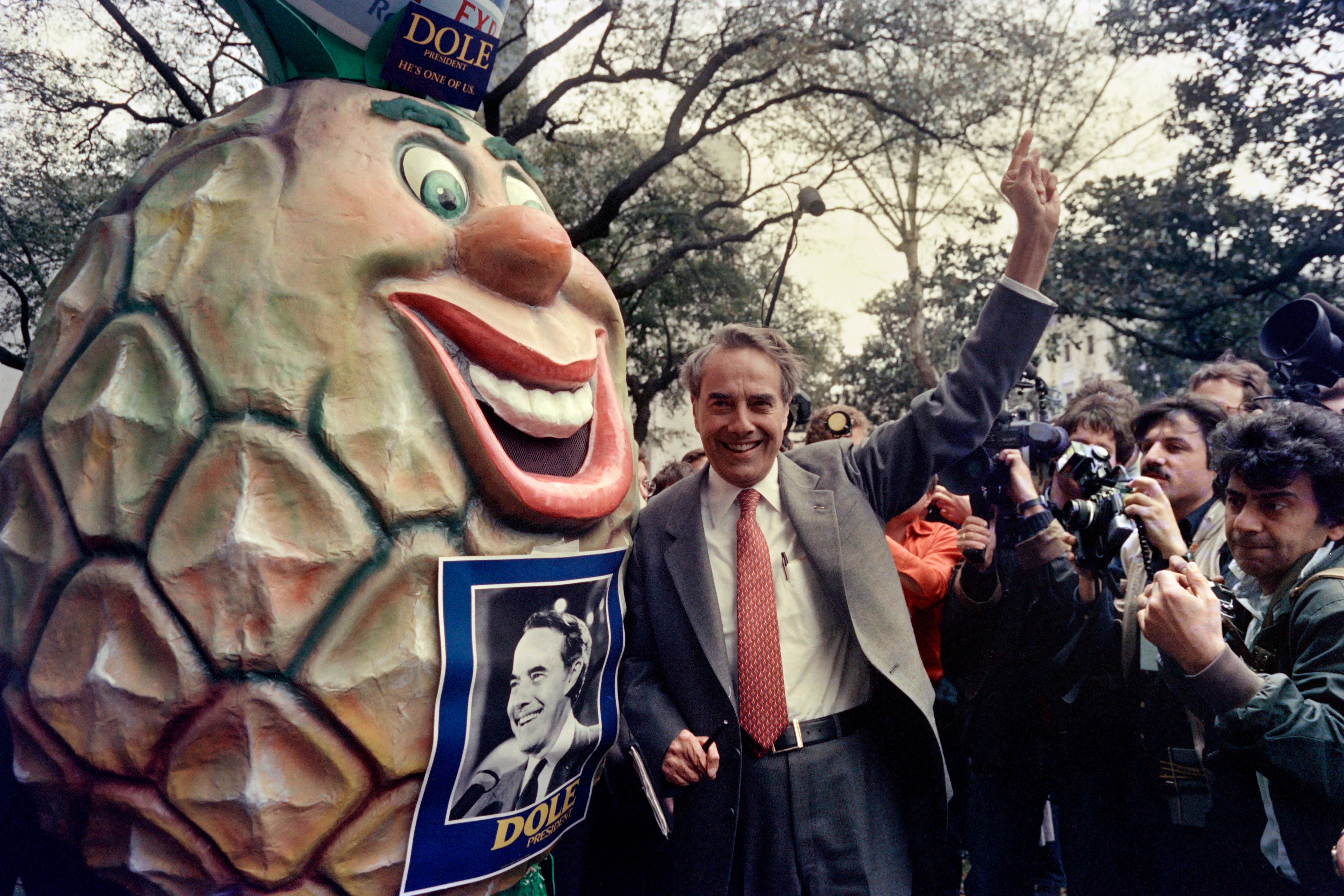 Republican presidential hopeful Senator Robert Dole, of Kansas, campaigns along side a giant pineapple on March 3, 1988 in Louisiana. (Photo by Mike SPRAGUE / AFP) (Photo credit should read MIKE SPRAGUE/AFP/Getty Images)