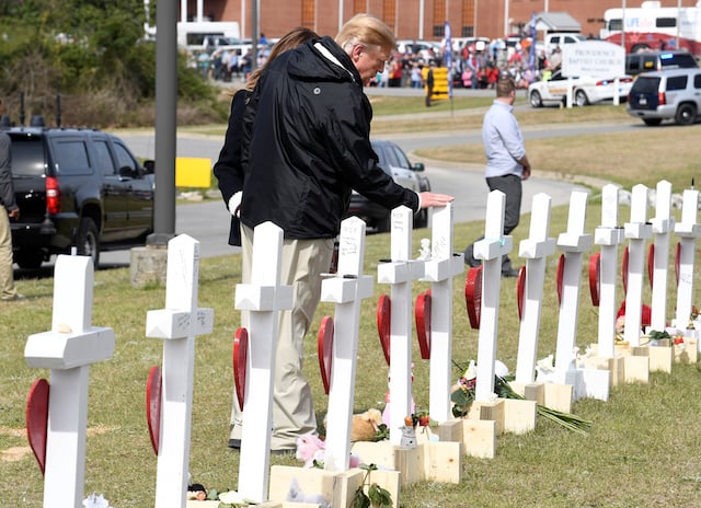 U.S. President Donald Trump and First Lady Melania Trump pause at a row of crosses for the victims of a tornado in Beauregard, Alabama, U.S., March 8, 2019. REUTERS/Mike Theiler