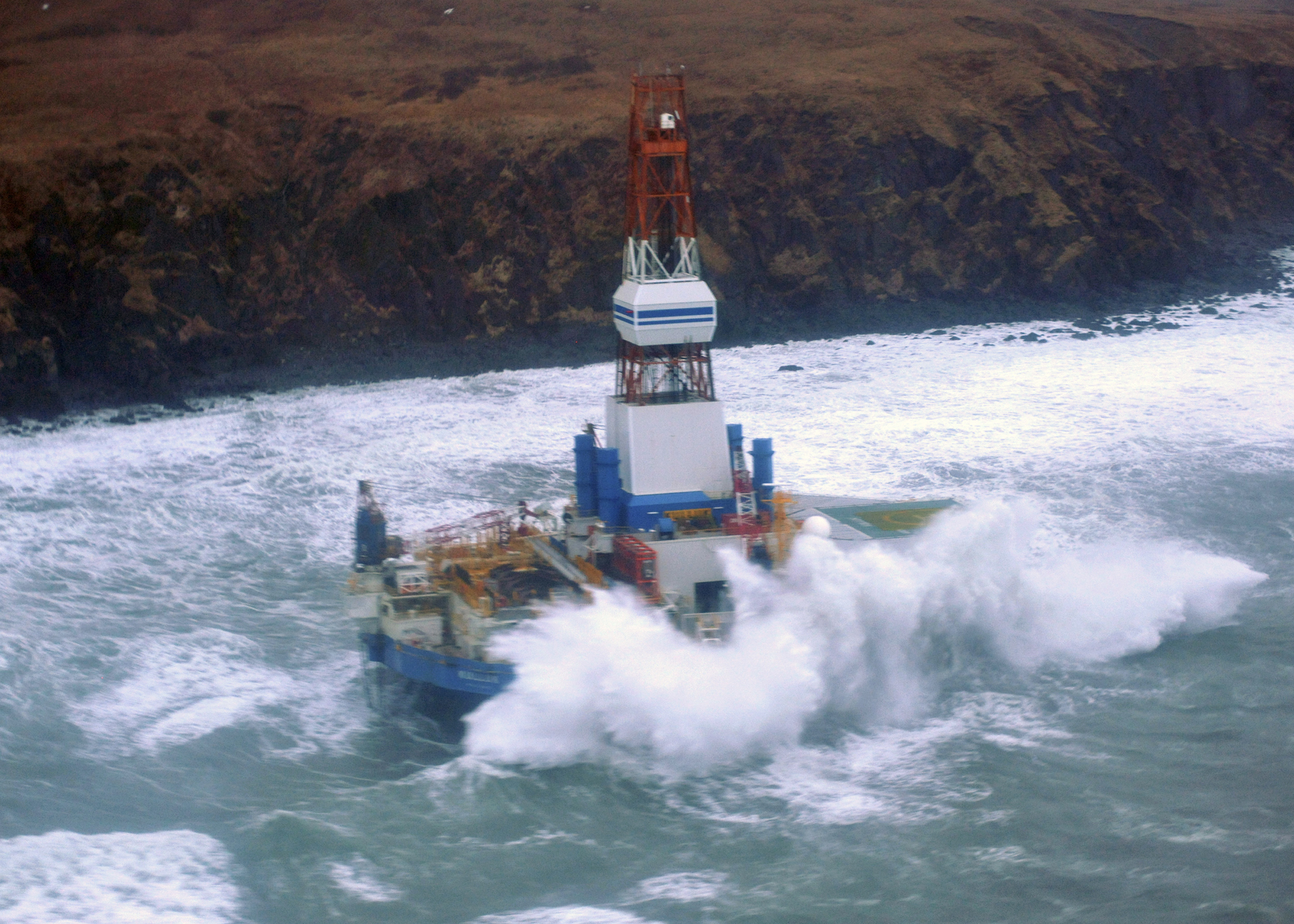 Waves crash over the conical drilling unit Kulluk where it sits aground on the southeast side of Sitkalidak Island, Alaska in this U.S. Coast Guard handout photo taken January 1, 2013. REUTERS/Petty Officer 3rd Class Jonathan Klingenberg'/USCG/Handout