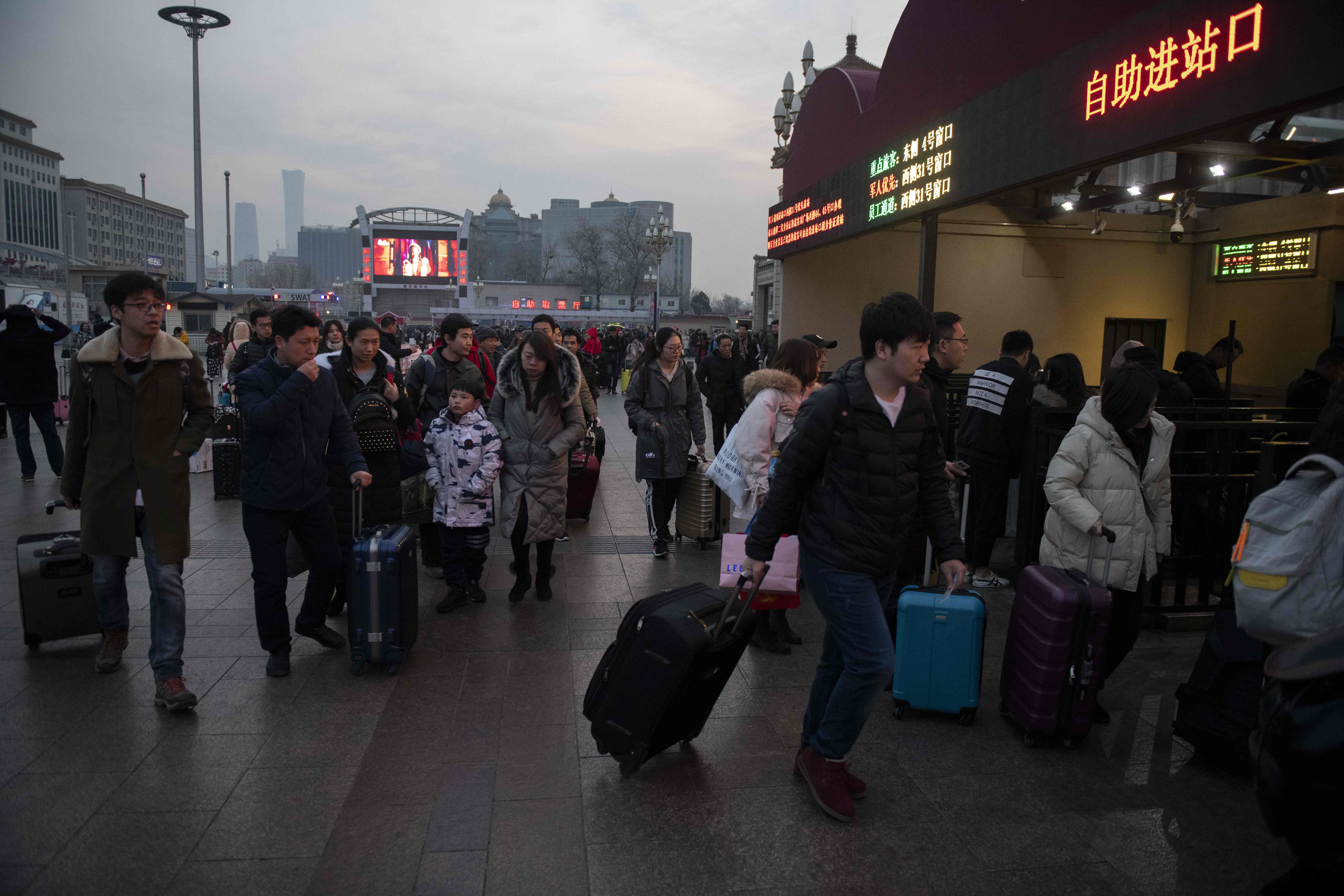 In this photo taken on January 29, 2019, travellers walk to the control gate at the Beijing railway station before taking trains ahead of the Lunar New Year. (NICOLAS ASFOURI/AFP/Getty Images)