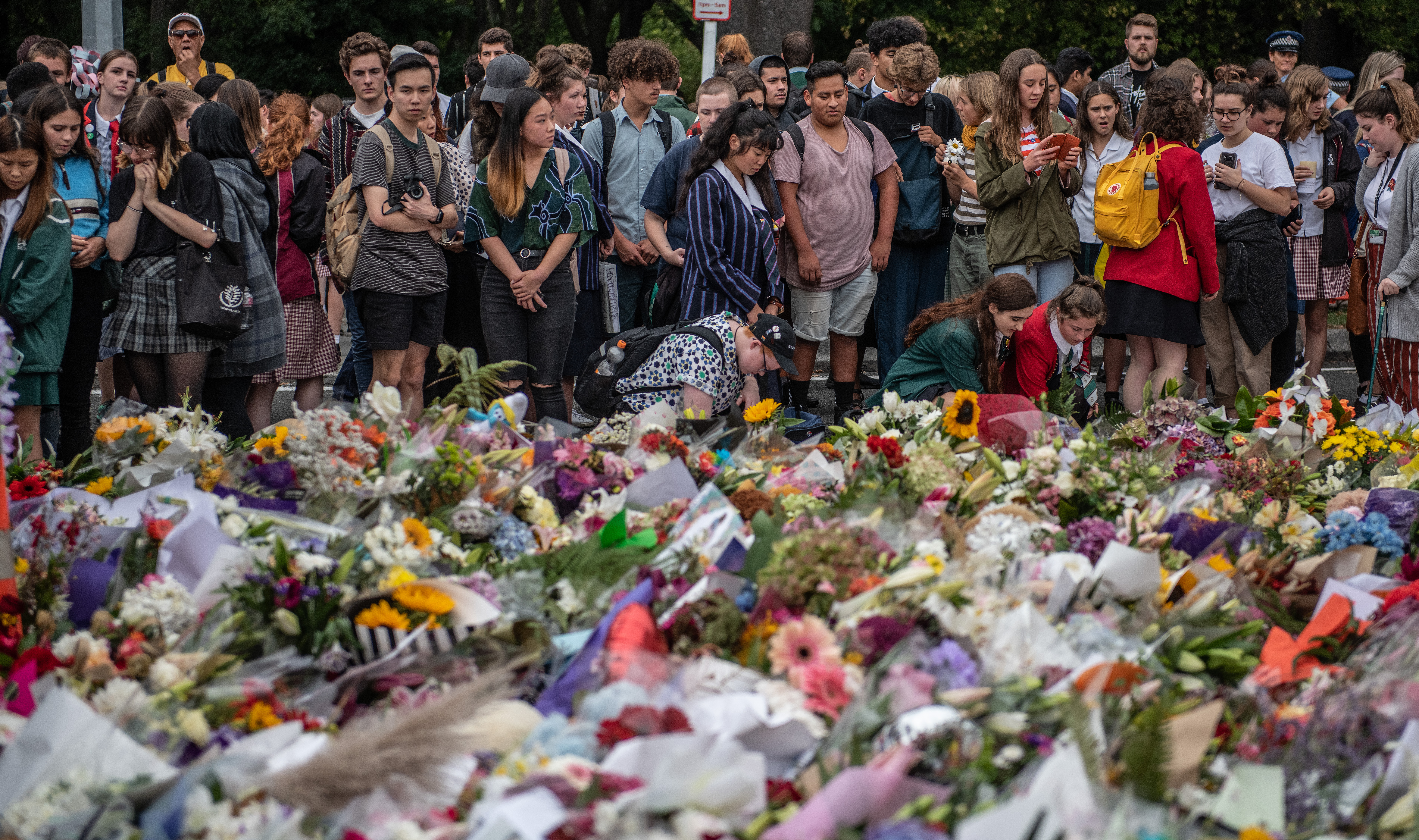 Schoolchildren and other well-wishers view flowers and tributes near Al Noor mosque on March 18, 2019 in Christchurch, New Zealand. (Photo by Carl Court/Getty Images)