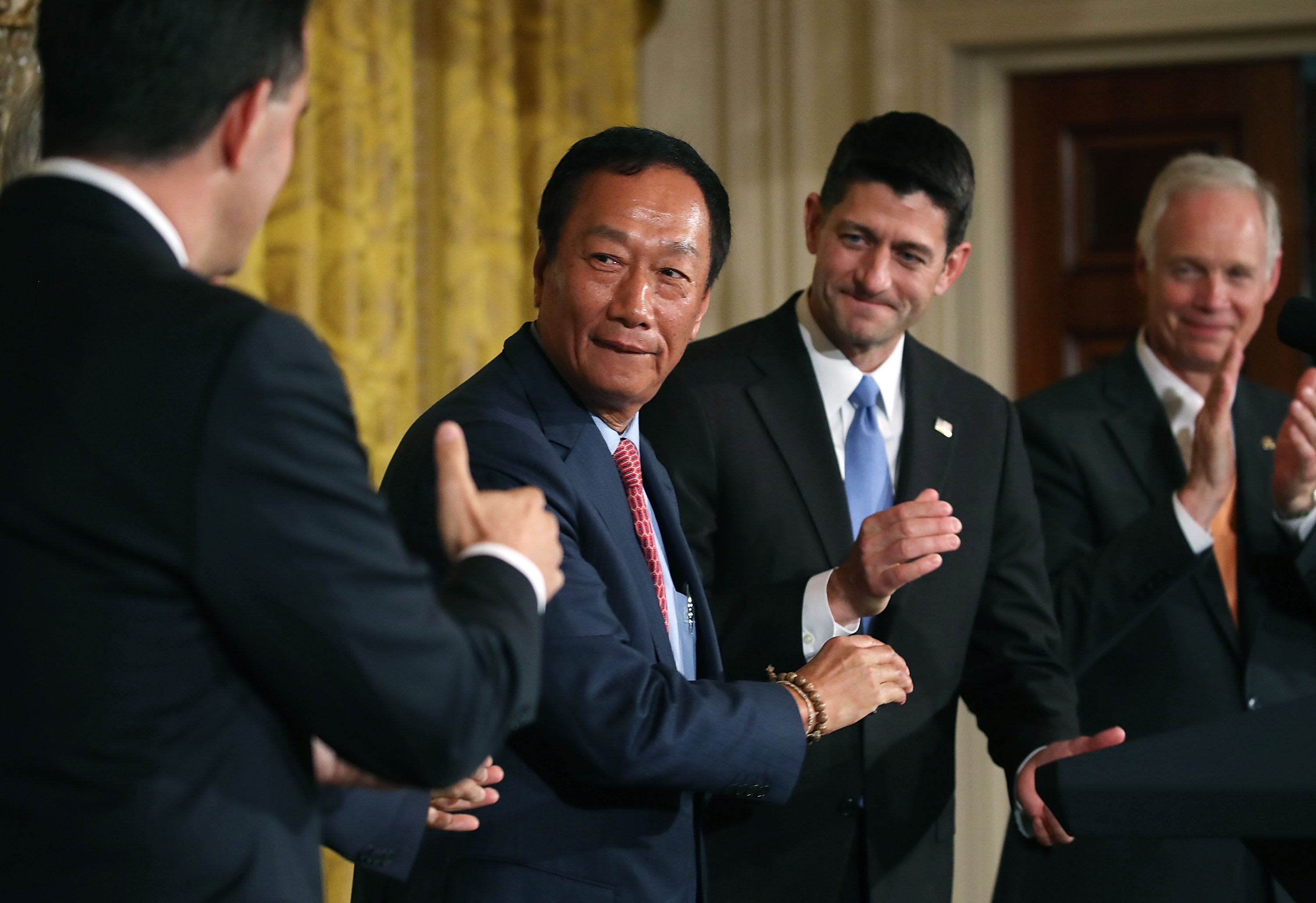 Terry Gou (2nd L), chairman of Apple supplier Foxconn, shakes hands with Wisconsin Gov. Scott Walker ... (Photo by Mark Wilson/Getty Images)
