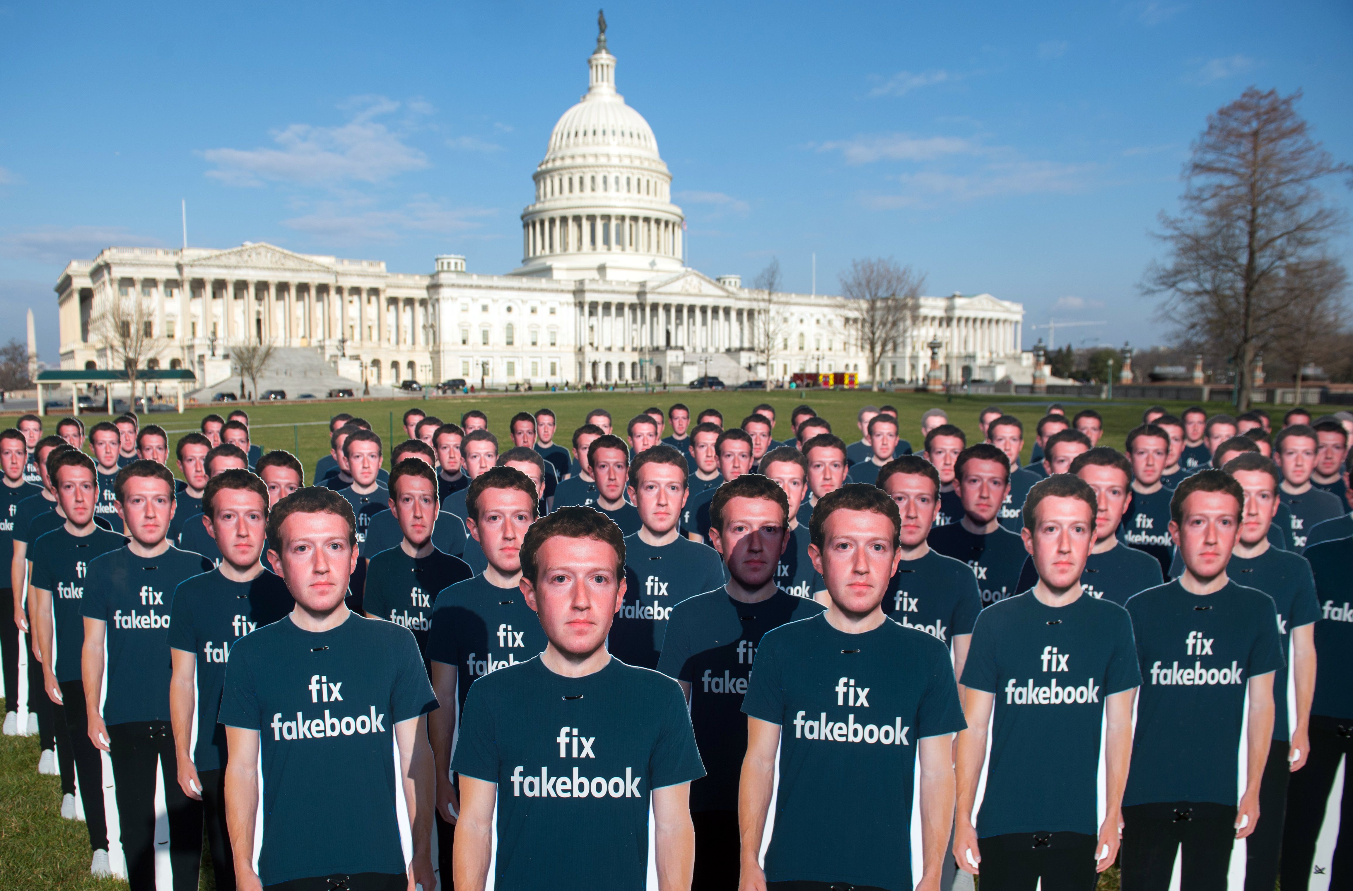 One hundred cardboard cutouts of Facebook founder and CEO Mark Zuckerberg stand outside the US Capitol in Washington, DC, April 10, 2018. - Advocacy group Avaaz is calling attention to what the groups says are hundreds of millions of fake accounts still spreading disinformation on Facebook.