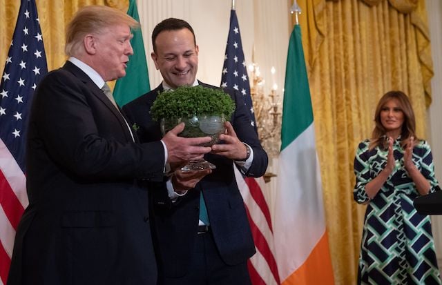 Irish Prime Minister Leo Varadkar presents a bowl of shamrocks to US President Donald Trump alongside US First Lady Melania Trump (R) during a Shamrock Bowl Presentation in honor of St. Patrick's Day in the East Room of the White House in Washington, DC, March 14, 2019. (Photo credit: SAUL LOEB/AFP/Getty Images)