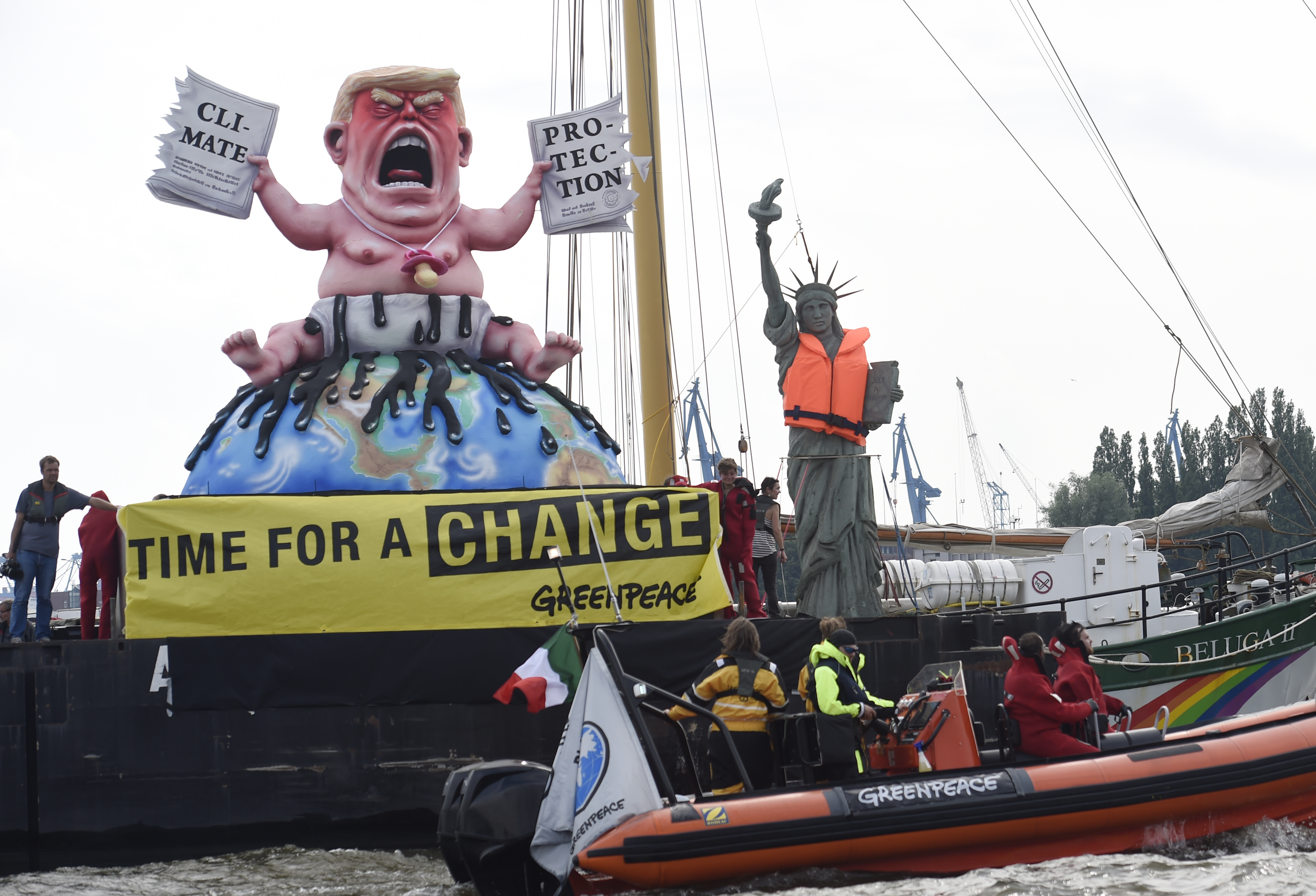 Greenpeace activists stay next to the giant statues depicting U.S. President Trump and Statue of Liberty during the protest at the G20 summit in Hamburg