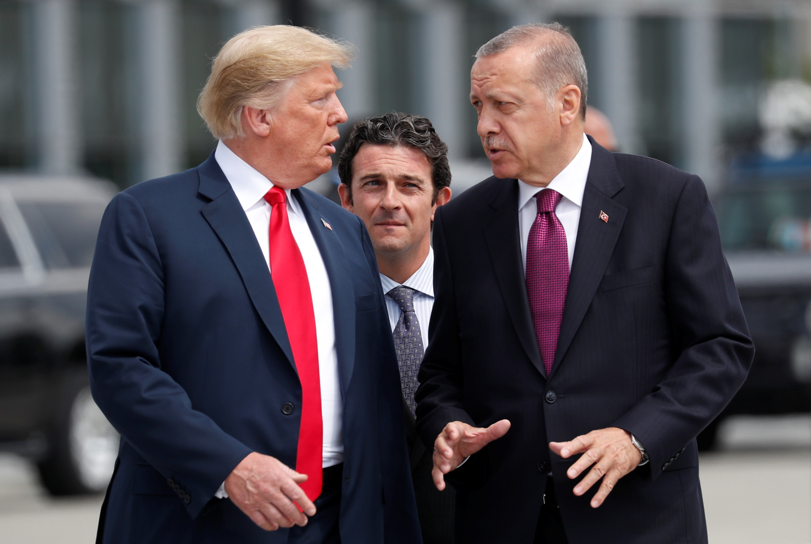 U.S. President Donald Trump and Turkish President Tayyip Erdogan gesture as they talk at the start of the NATO summit in Brussels, Belgium July 11, 2018. REUTERS/Kevin Lamarque