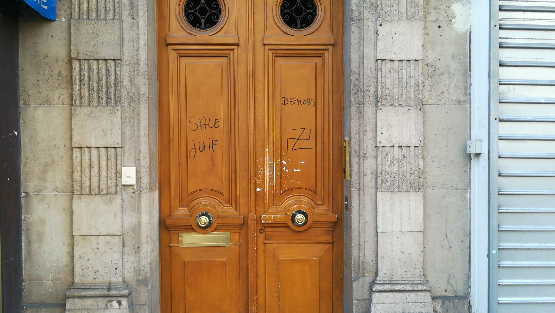 A picture taken on February 21, 2019 in the rue d'Alesia in the 14th arrondissement of Paris shows anti-Semitic tags reading "dirty Jew, get out" and a swastika tagged on a door. (ALEXANDRE HIELARD/AFP/Getty Images)