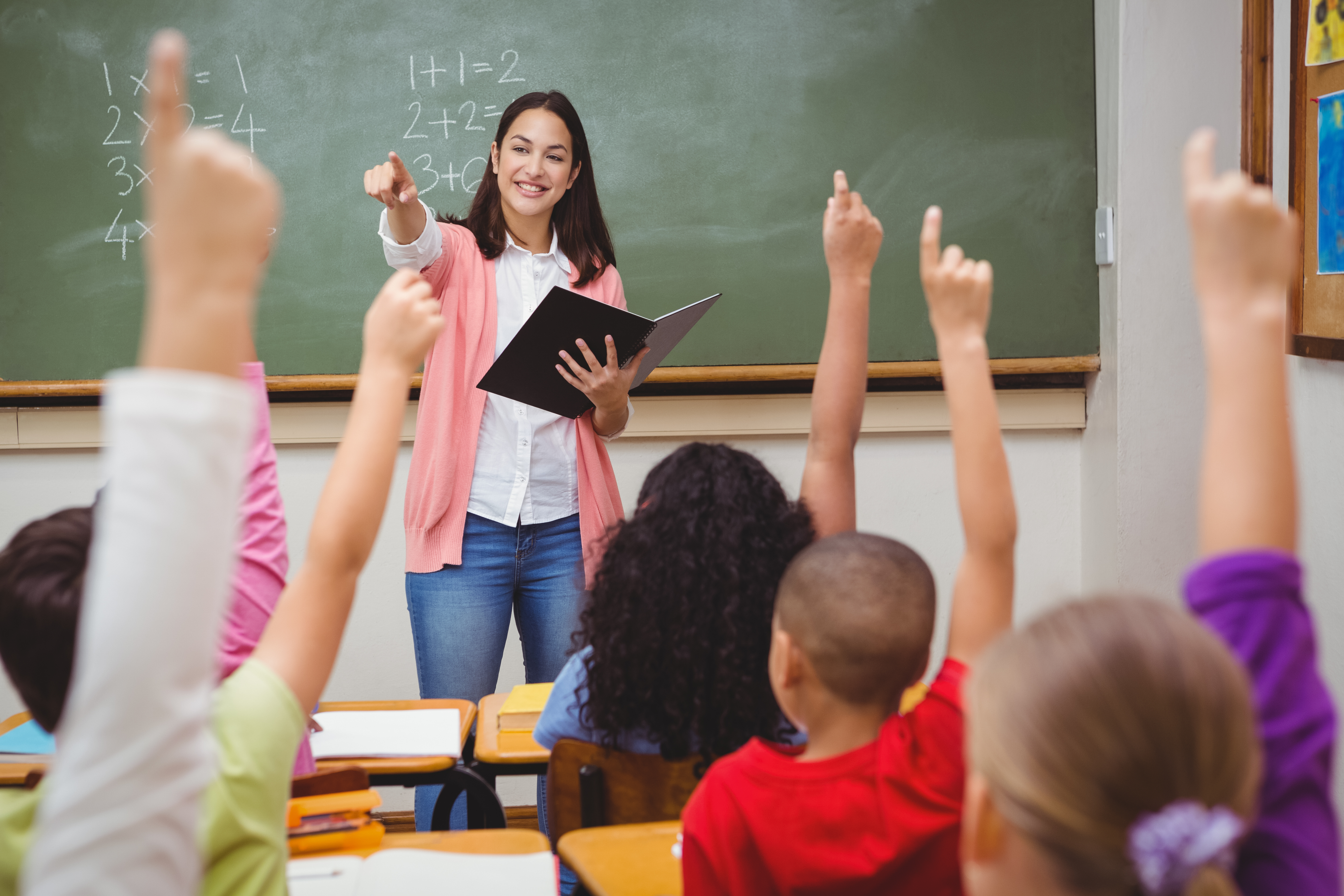Pictures is a teacher with her students in class. SHUTTERSTOCK/ wavebreakmedia