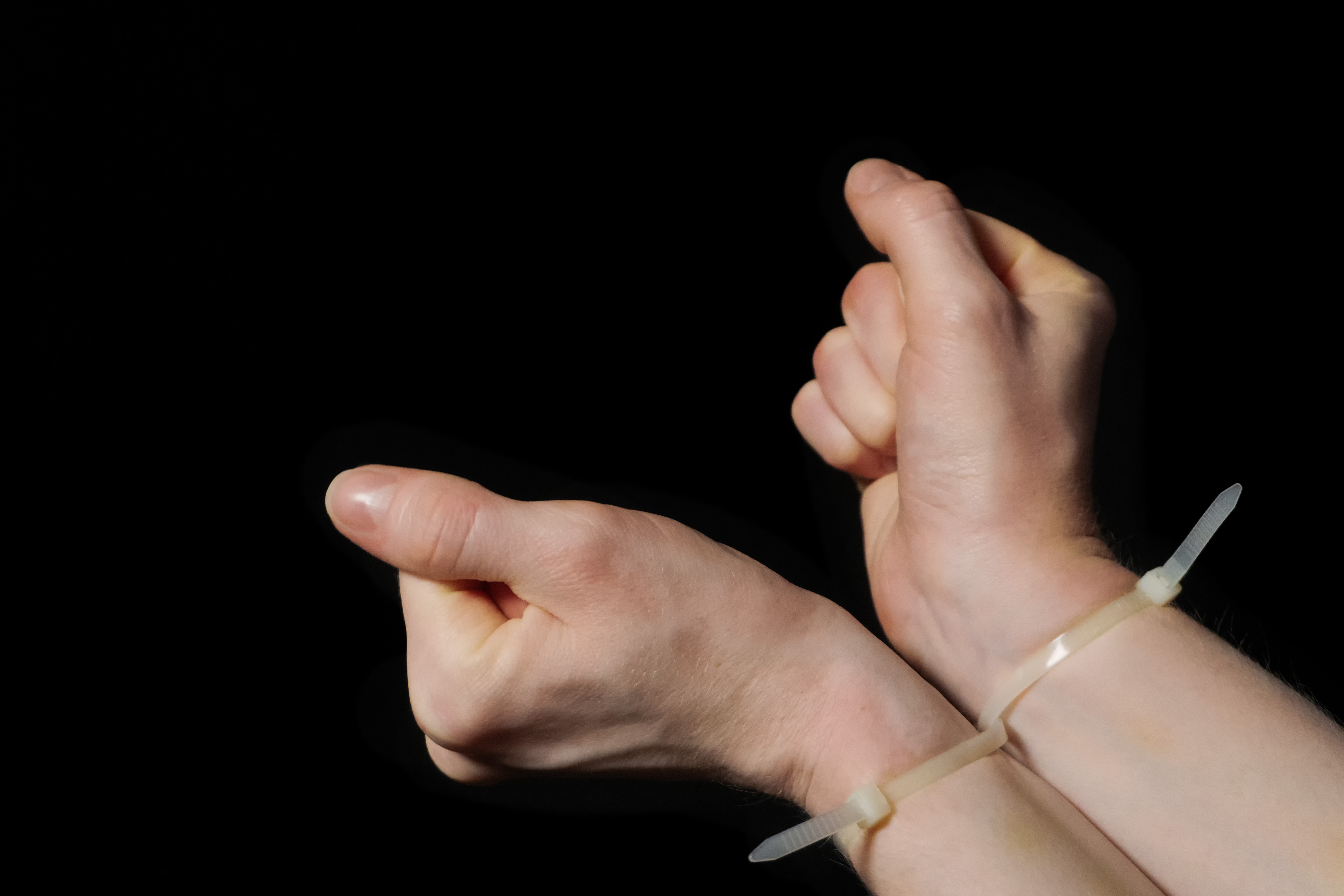 Pictured are hands restricted by a zip tie. SHUTTERSTOCK/ Nick Vakhrushev
