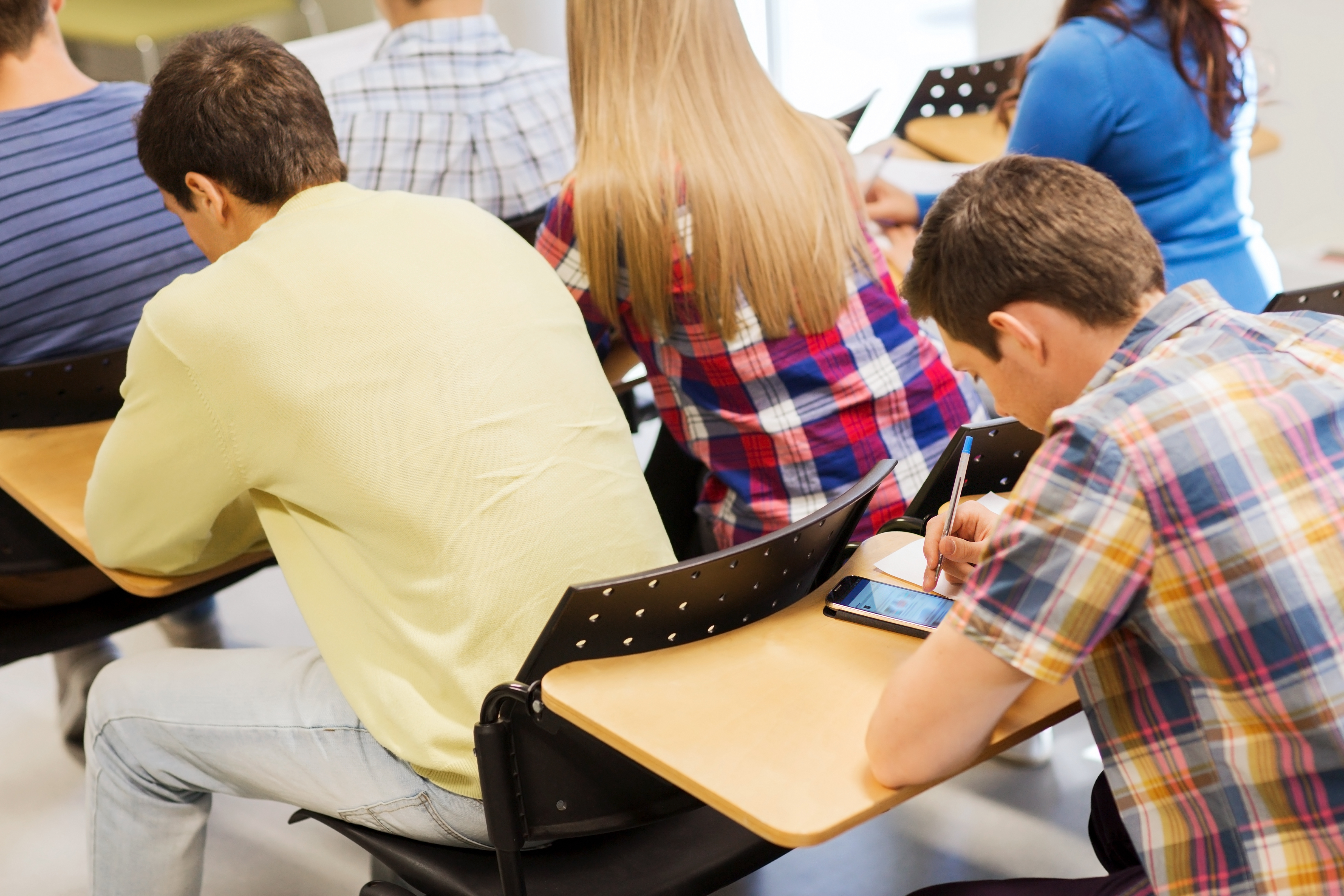 Pictured is a student using a cell phone during class. SHUTTERSTOCK/ Syda Productions