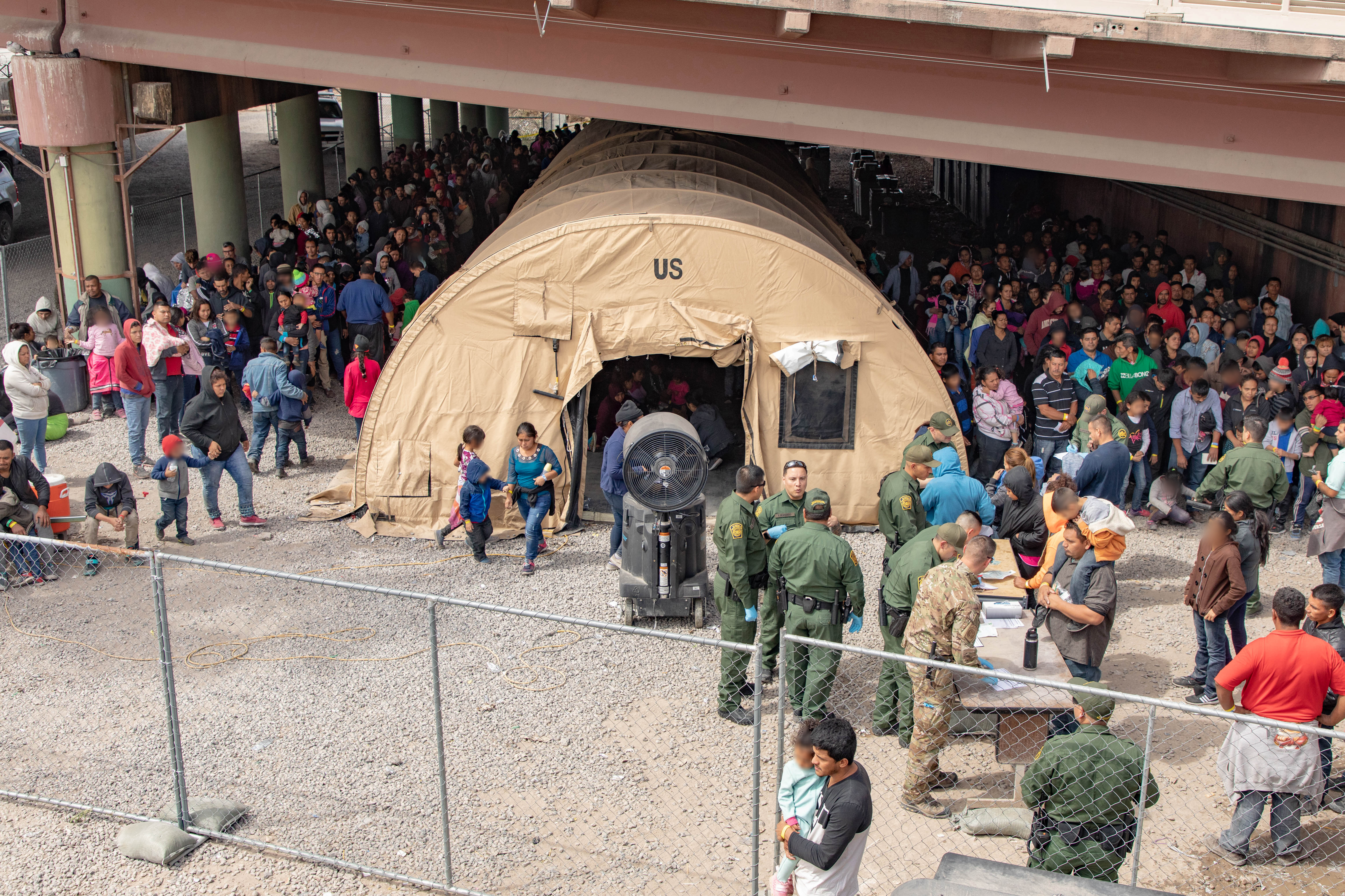 U.S. Border Patrol agents provide food, water and medical screening to scores of migrants at a processing center after crossing the international border between the United States and Mexico on March 22, 2019 in El Paso, Texas. (Mani Albrecht/U.S. Customs and Border Protection via Getty Images)