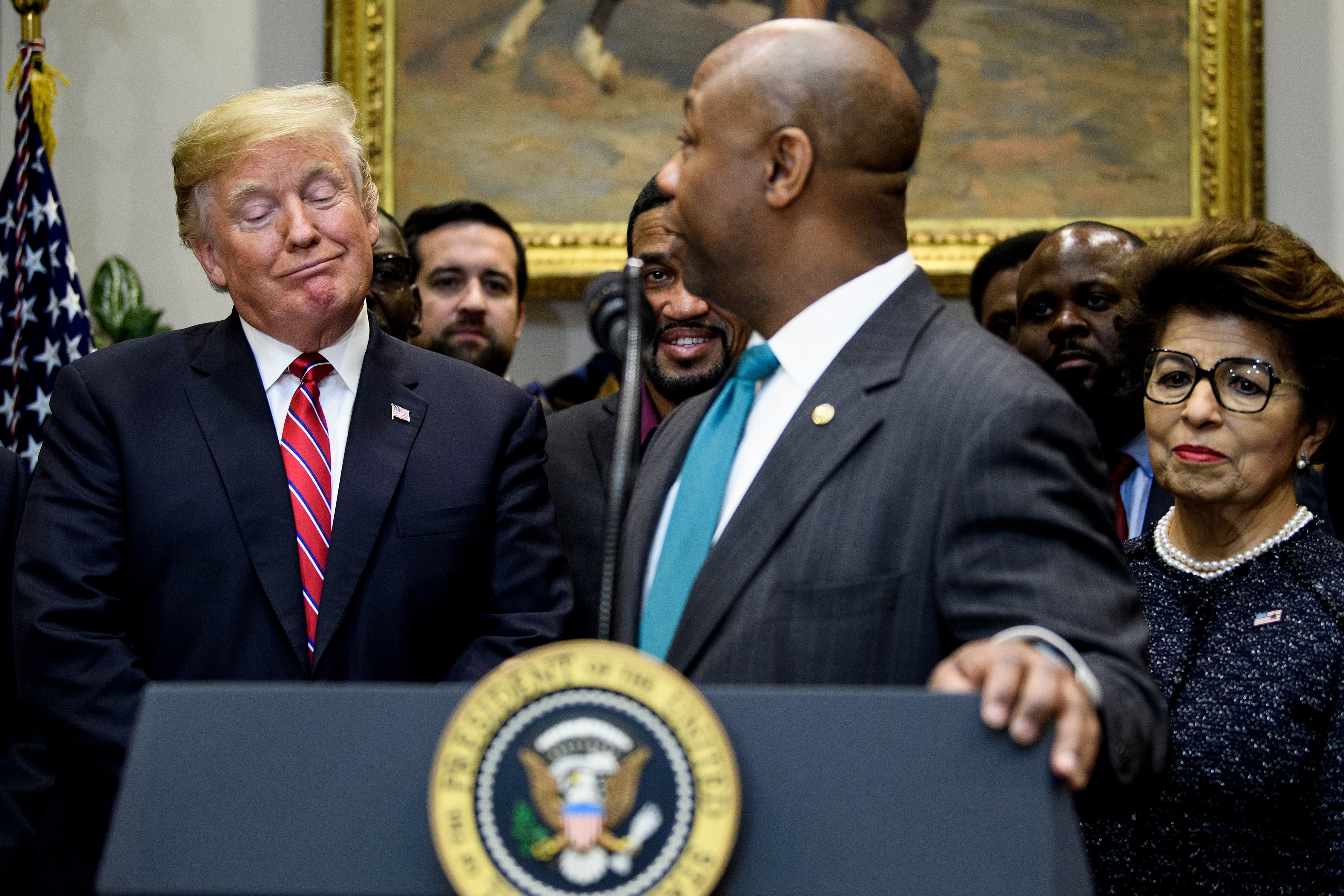 US President Donald Trump (L), US Treasurer Jovita Carranza (R), and others listen while US Senator Tim Scott speaks during an executive order signing event for the "White House Opportunity and Revitalization Council " in the Roosevelt Room of the White House December 12, 2018 in Washington, DC. (BRENDAN SMIALOWSKI/AFP/Getty Images)