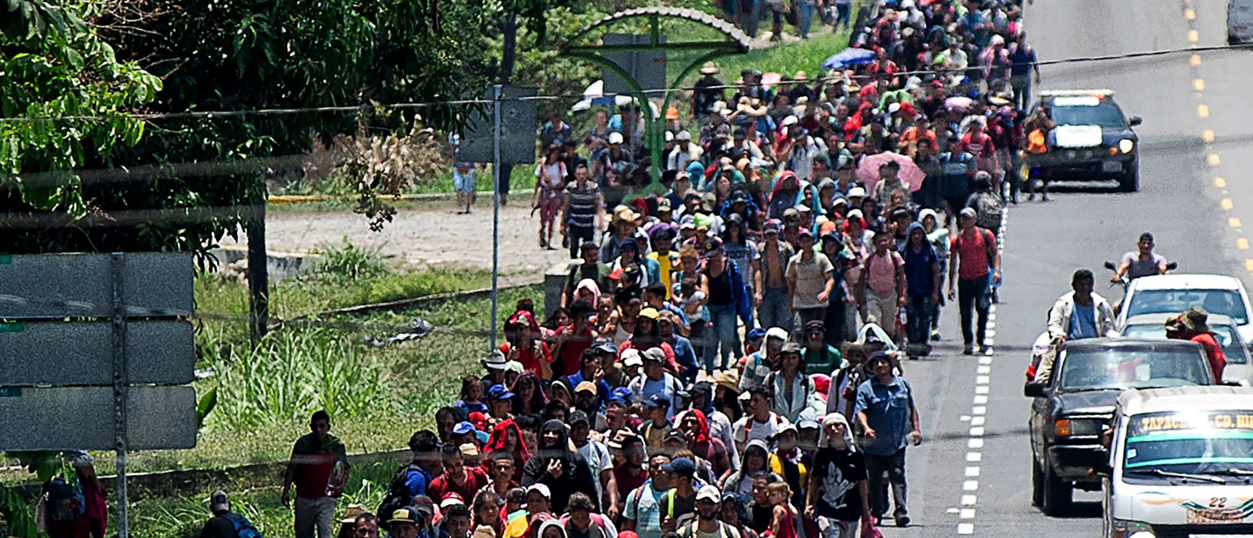 Central American migrants heading to the US walk in caravan along the route between Metapa and Tapachula in Mexico on April 12, 2019. - A group of 350 Central American migrants forced their way into Mexico Friday, authorities said, as a new caravan of around 2,500 people arrived -- news sure to draw the attention of US President Donald Trump. Mexico's National Migration Institute said some members of the caravan had a "hostile attitude" and had attacked local police in the southern town of Metapa de Dominguez after crossing the border from Guatemala. (Photo by Pep COMPANYS / AFP/Getty Images)