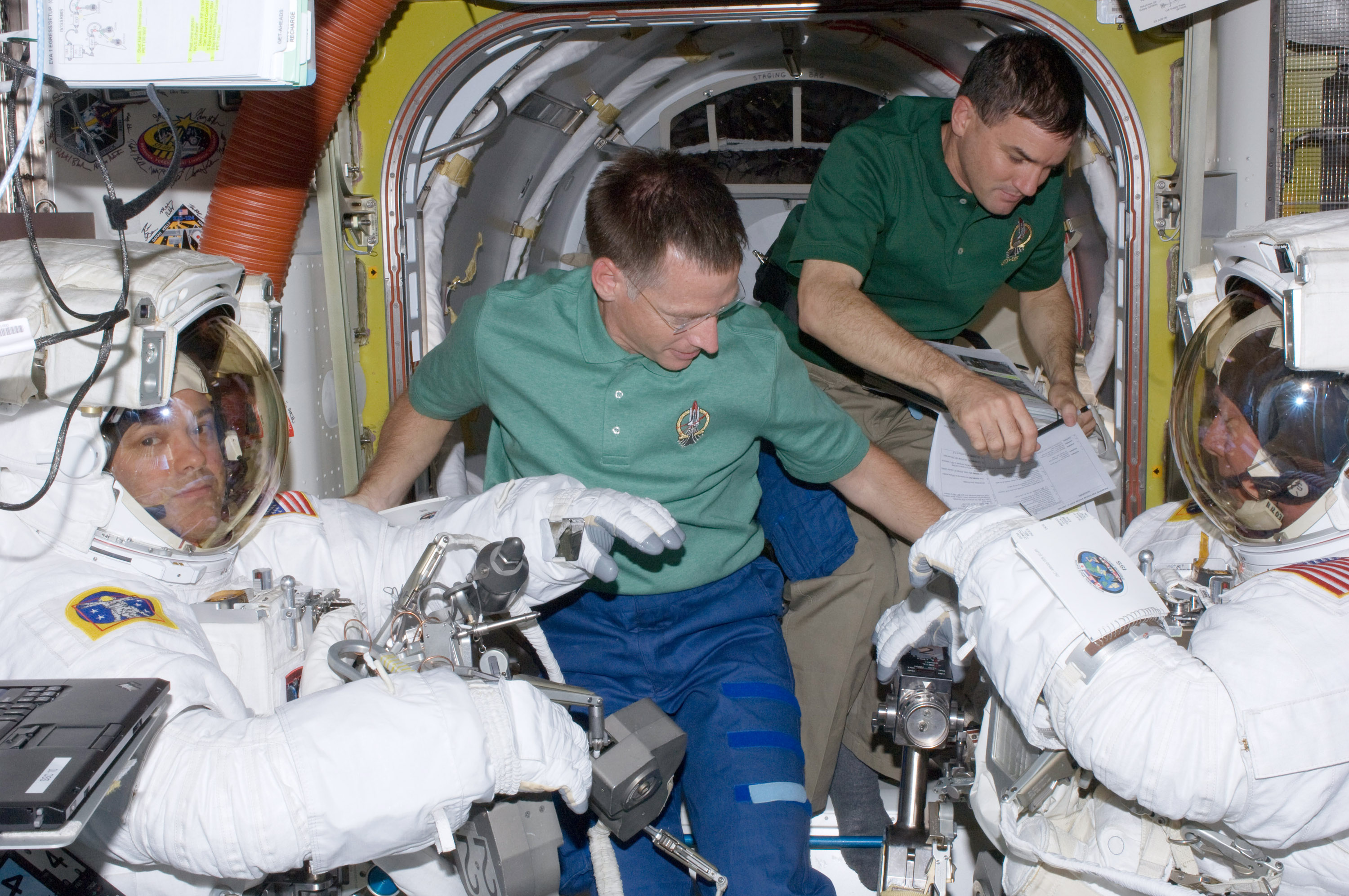 IN SPACE - JULY 12: In this handout image provided by the National Aeronautics and Space Administration (NASA), Wearing extravehicular mobility unit space suits, NASA astronauts Mike Fossum (right), and Ron Garan, both Expedition 28 flight engineers, are assisted by NASA astronauts Chris Ferguson (foreground) and Rex Walheim in the International Space Station's Quest airlock prior to the July 12 spacewalk during which Fossum and Garan egressed the orbiting complex to complete some needed chores July 12, 2011 in space. (NASA via Getty Images)