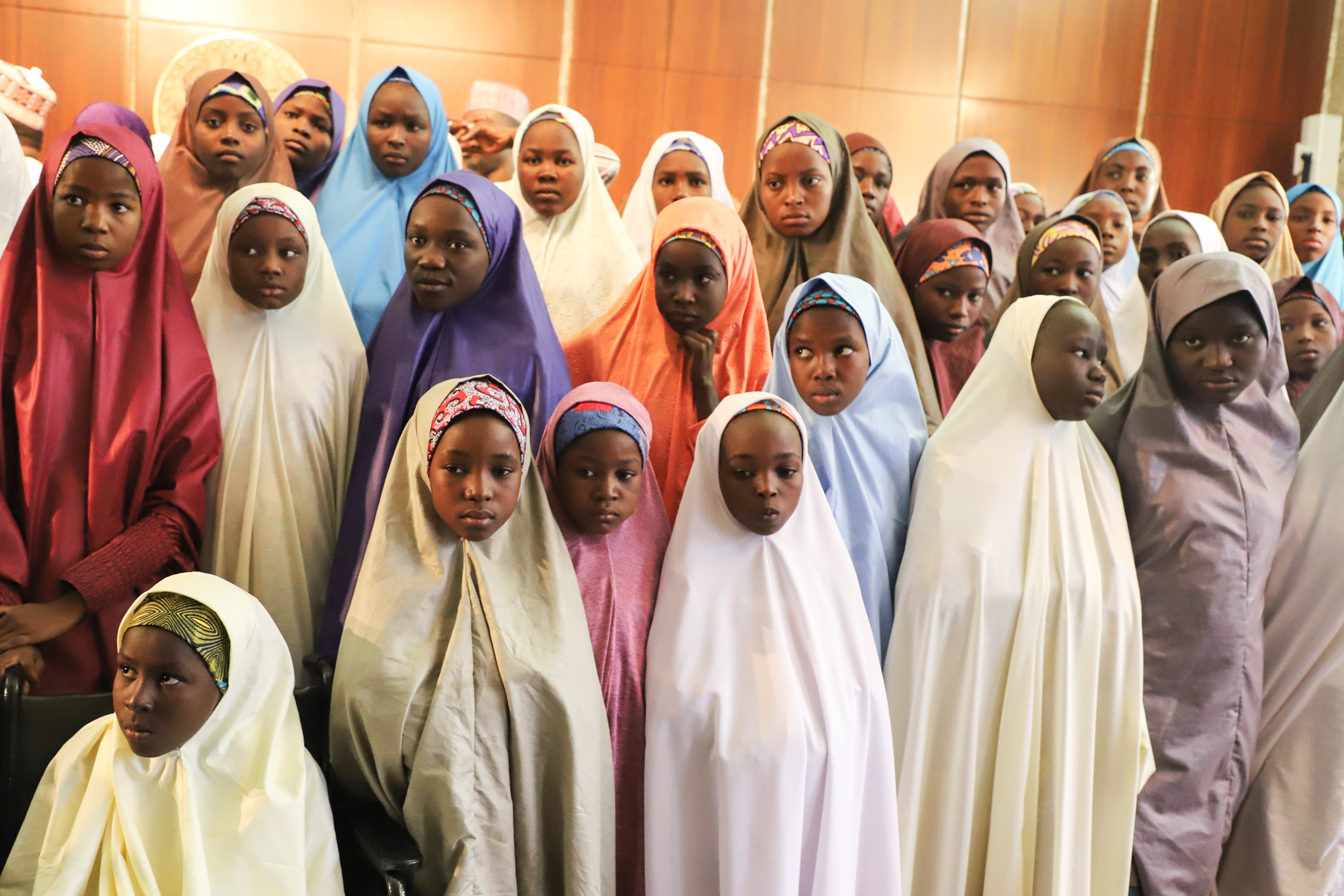 TOPSHOT - Released Nigerian school girls who were kidnapped from their school in Dapchi, in the northeastern state of Yobe, wait to meet the Nigerian president at the Presidential Villa in Abuja on March 23, 2018. The Nigerian president promised on March 23, 2018 to free the remaining Christian schoolgirl still held by the Islamist militants Boko Haram, as he prepared to meet the other released Dapchi students. A total of 104 of the 110 students seized from the school in Dapchi on February 19 were released on March 21, 2018. / AFP PHOTO / PHILIP OJISUA / The erroneous mention[s] appearing in the metadata of this photo by PHILIP OJISUA has been modified in AFP systems in the following manner: [school girls ] instead of [Christian school girls ]. Please immediately remove the erroneous mention[s] from all your online services and delete it (them) from your servers. If you have been authorized by AFP to distribute it (them) to third parties, please ensure that the same actions are carried out by them. Failure to promptly comply with these instructions will entail liability on your part for any continued or post notification usage. Therefore we thank you very much for all your attention and prompt action. We are sorry for the inconvenience this notification may cause and remain at your disposal for any further information you may require. (Photo credit should read PHILIP OJISUA/AFP/Getty Images)