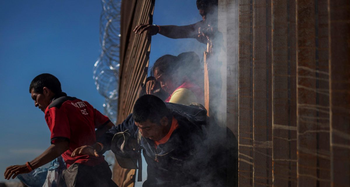 Migrants, part of a caravan of thousands from Central America trying to reach the United States, return to Mexico after being hit by tear gas by U.S. Customs and Border Protection officials after attempting to illegally cross the border wall into the United States in Tijuana, Mexico, Nov. 25, 2018. REUTERS/Adrees Latif