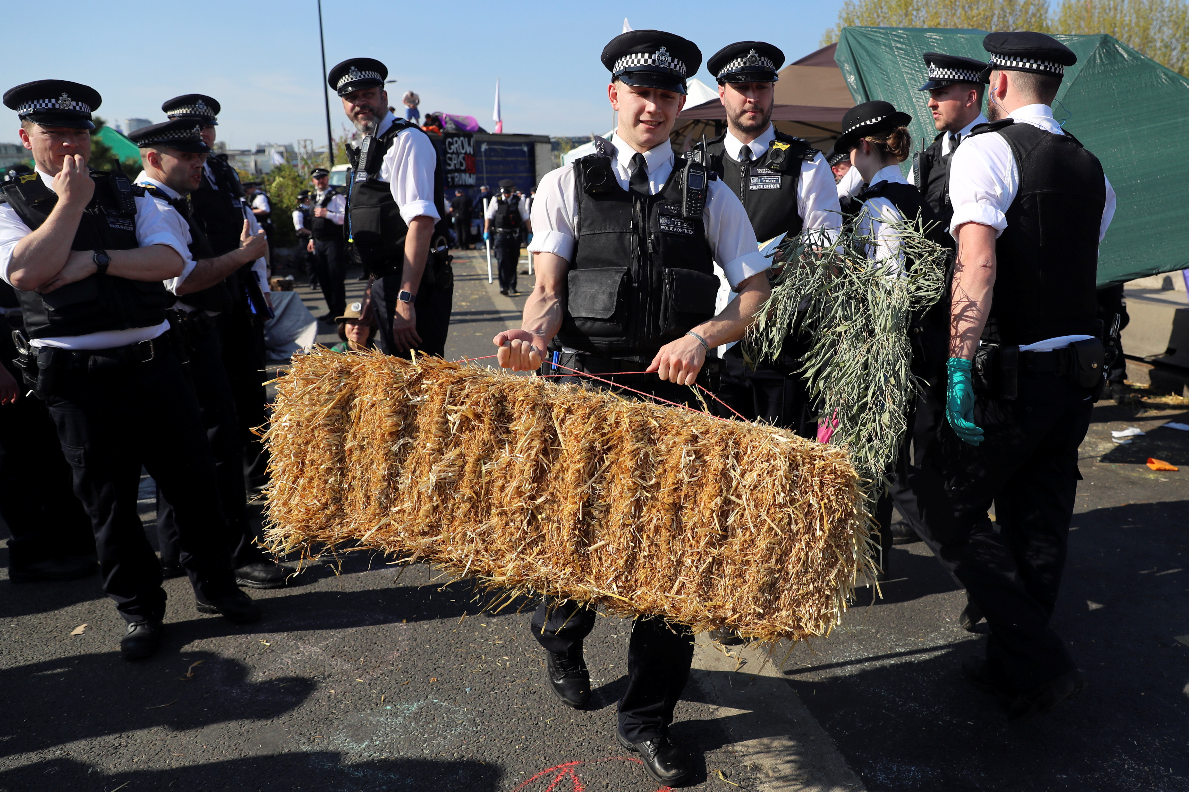 A police officer removes a haystack during the Extinction Rebellion protest on Waterloo Bridge in London, Britain April 20, 2019. REUTERS/Simon Dawson