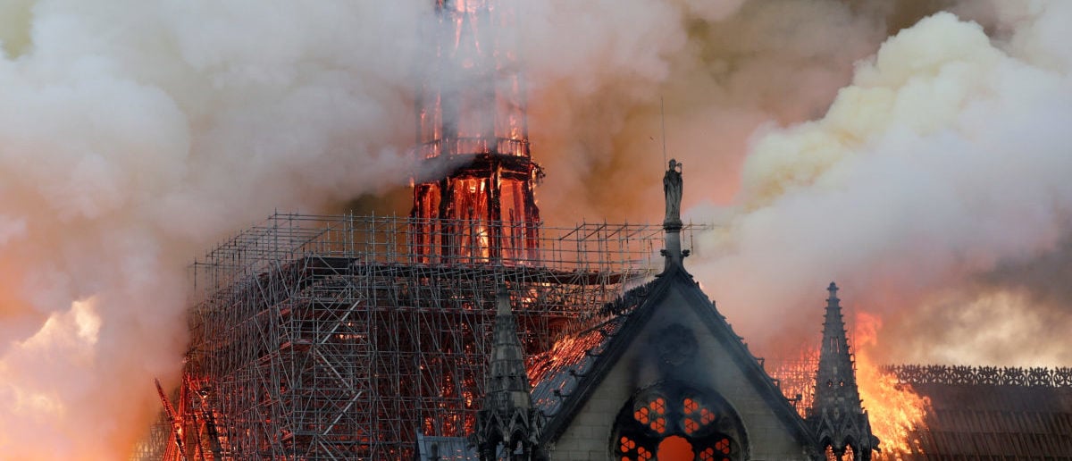 Smoke billows as fire engulfs the spire of Notre Dame Cathedral in Paris, France April 15, 2019. REUTERS/Benoit Tessier