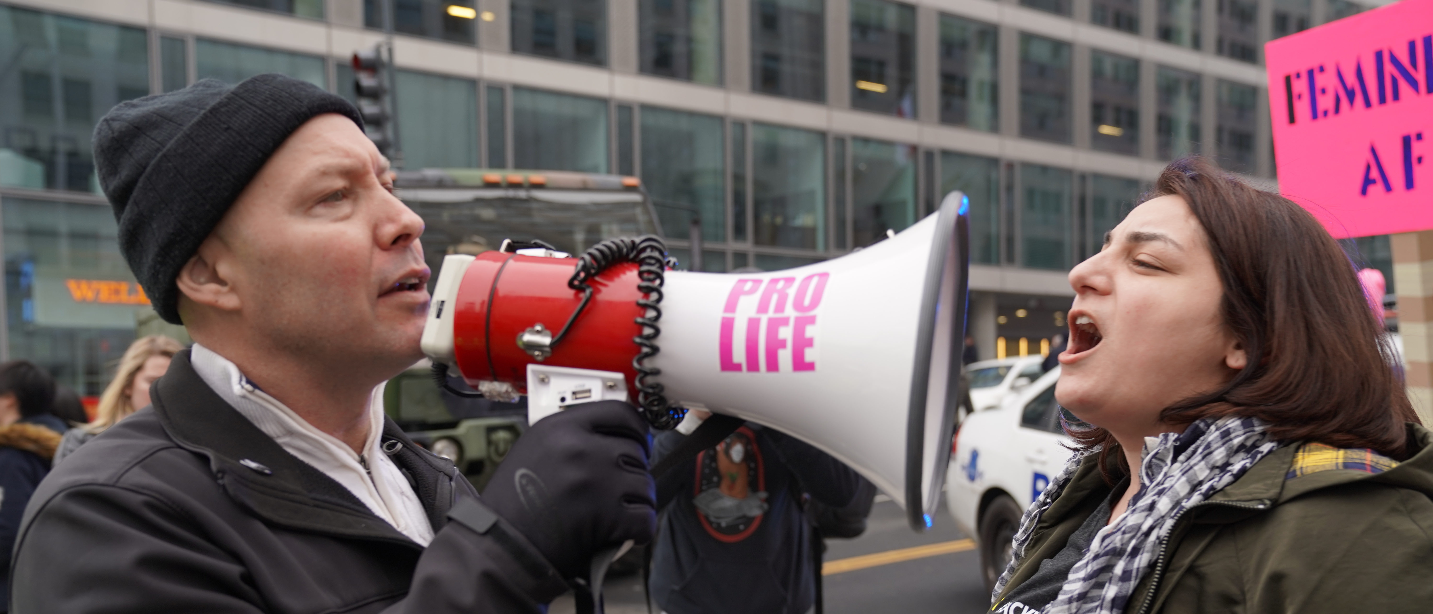 January 19, 2019: An abortion supporter shouts into a bull horn of an anti-abortion activist under police protection at the 2019 Women’s March. Shutterstock/Phil Pasquini