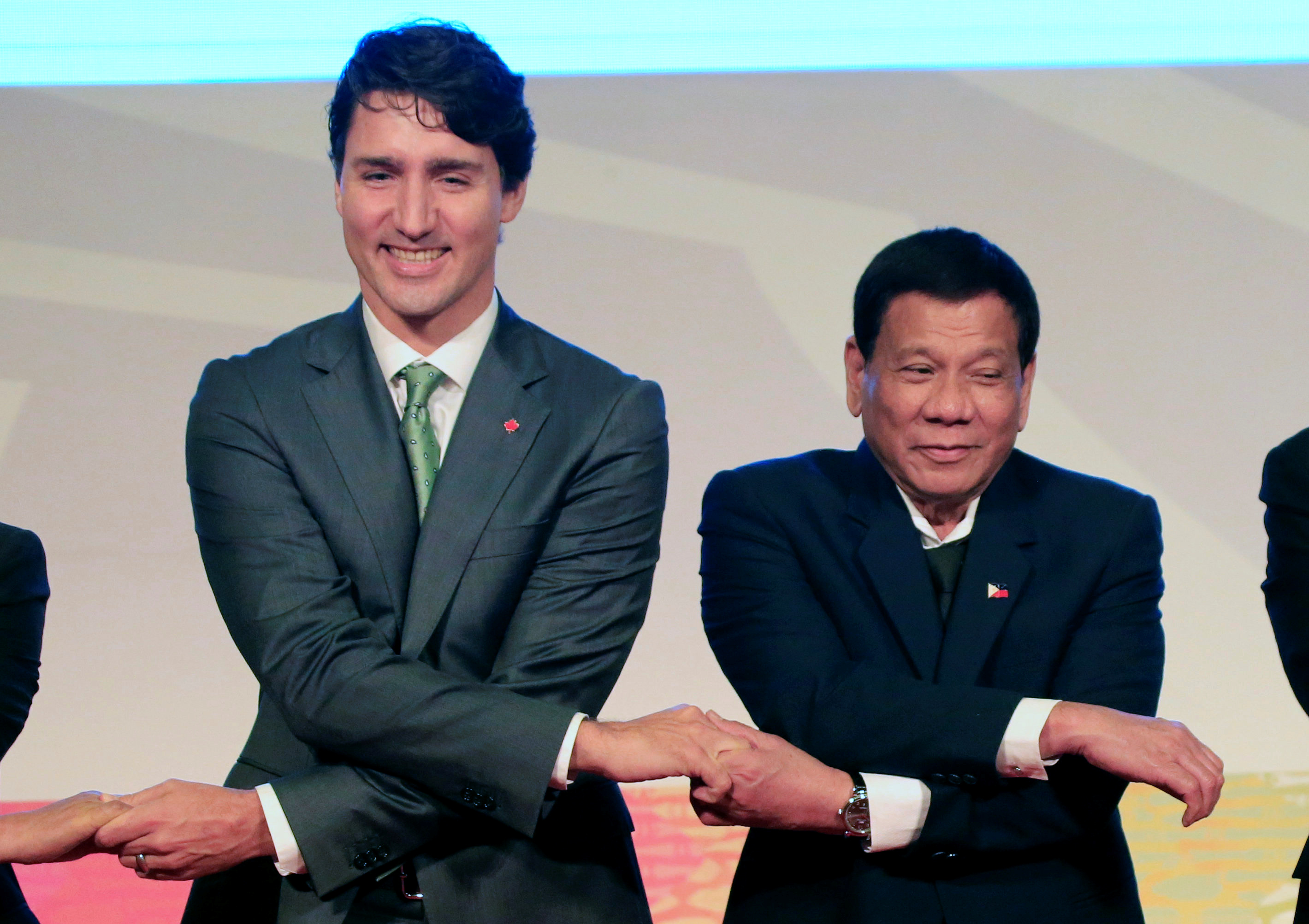 Philippines' President Rodrigo Duterte holds hands with Canada Prime Minister Justin Trudeau for a family photo during the ASEAN-Canada 40th anniversary commerative summit in metro Manila, Philippines November 14, 2017. REUTERS/Romeo Ranoco