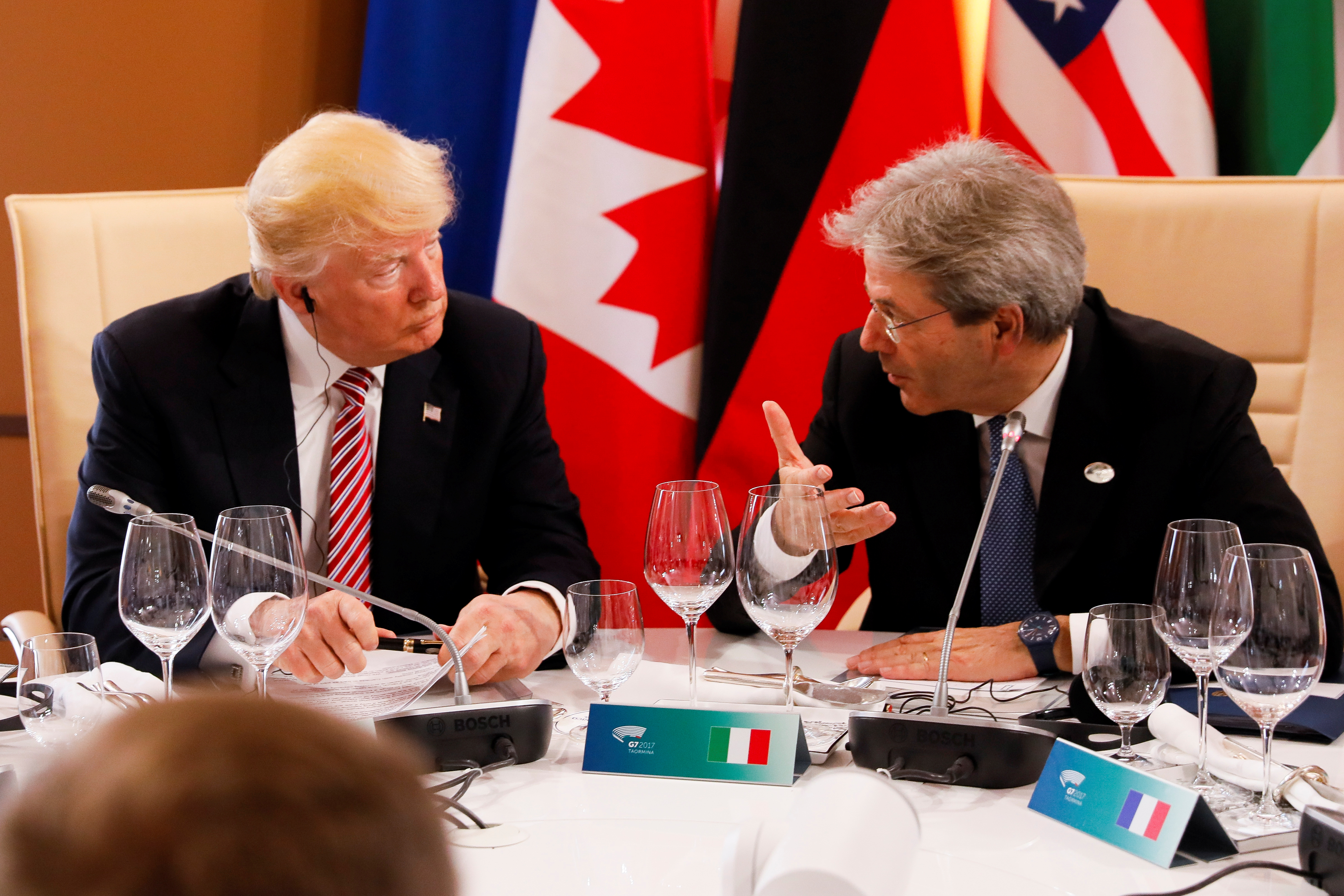 U.S. President Donald Trump (L) listens to Italian Prime Minister Paolo Gentiloni as they sit around a table during the G7 Summit in Taormina, Sicily, Italy, May 26, 2017. REUTERS/Jonathan Ernst