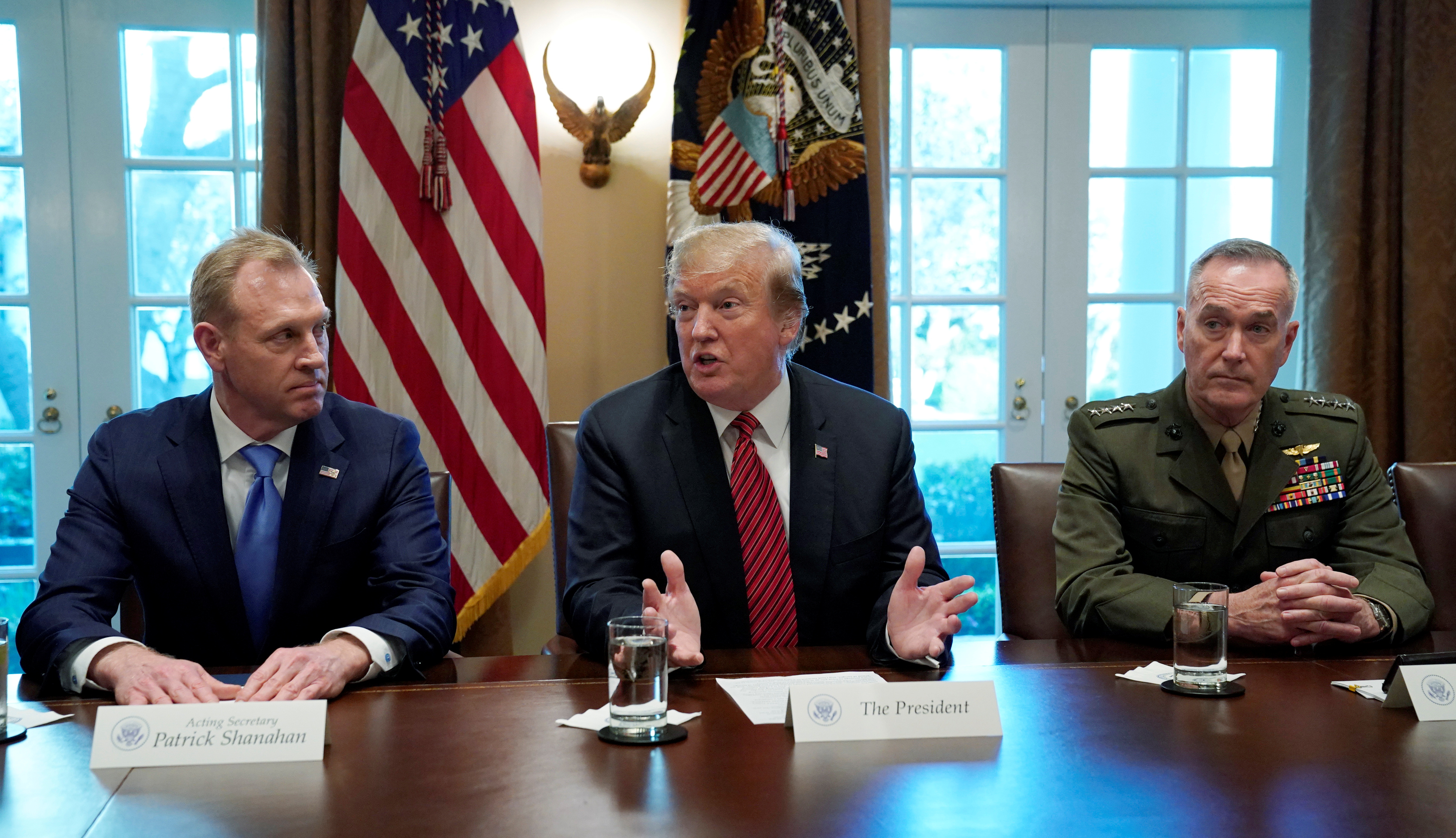 Acting Defense Secretary Patrick Shanahan (L) and Chairman of the Joint Chiefs of Staff Gen. Joseph Dunford (R) listen as U.S. President Donald Trump holds a meeting with senior military leaders at the White House in Washington, U.S., April 3, 2019. REUTERS/Kevin Lamarque