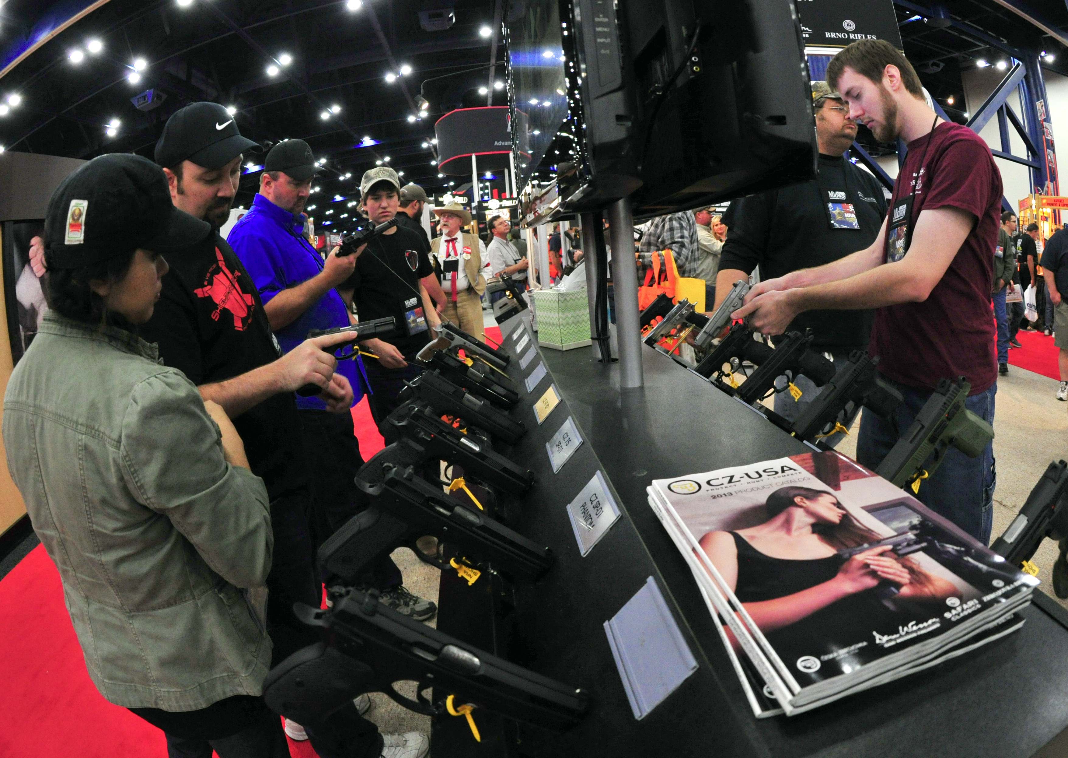 Convention goers look at handguns at the CZ-USA booth at the NRA(National Rifle Association) Convention May 4, 2013 in Houston, Texas.(Photo by KAREN BLEIER/AFP/Getty Images)